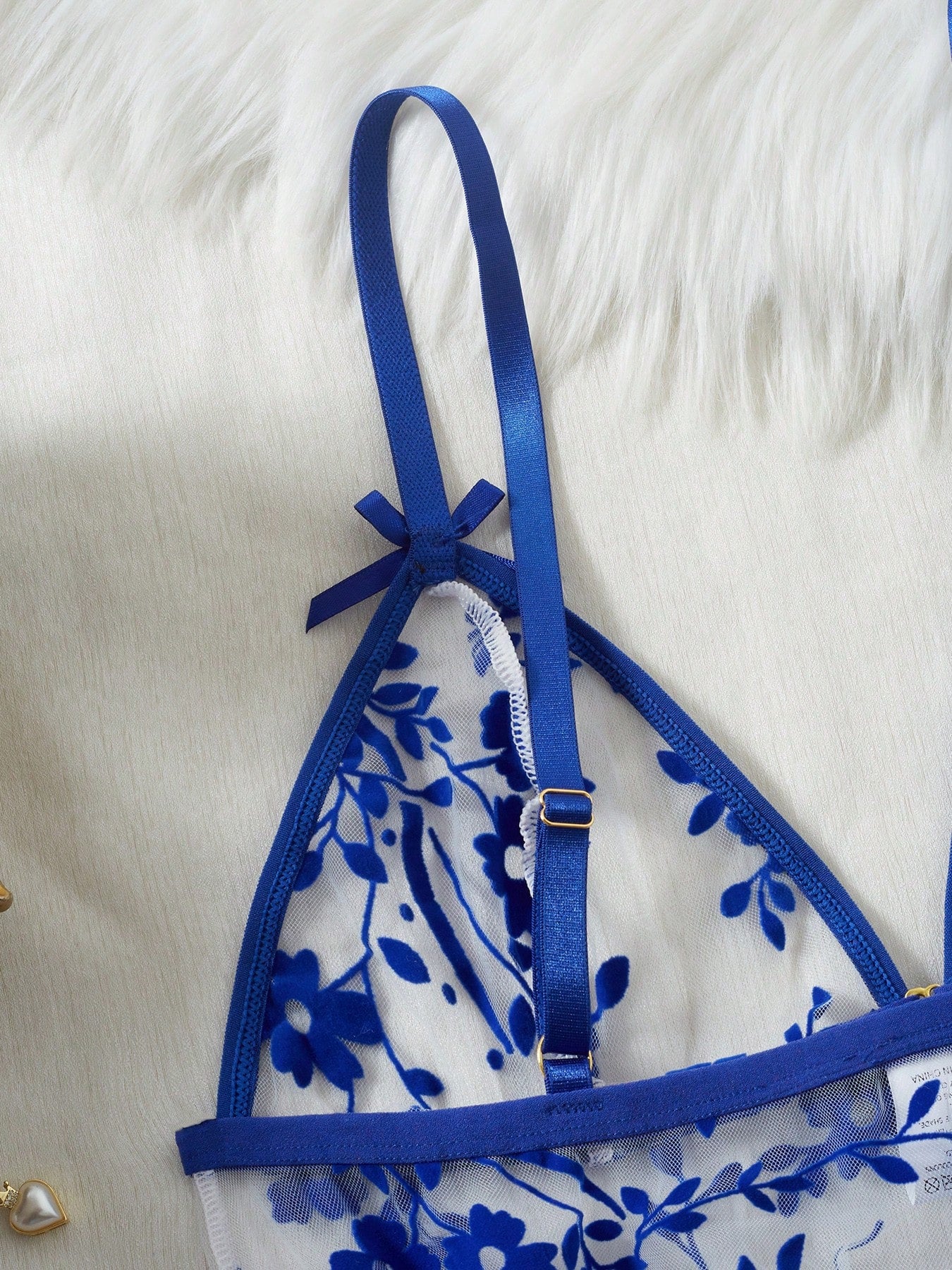 Two-piece women’s floral mesh sleepwear set featuring a front-clasp sheer embroidered bralette with adjustable spaghetti straps and a matching low-rise thong.