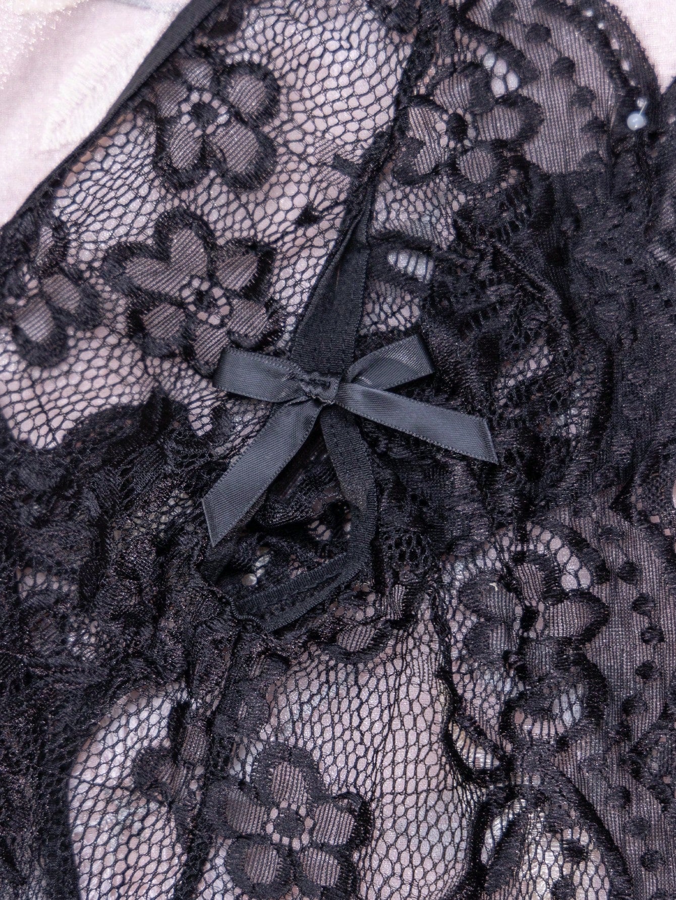 Women’s 1-piece crotchless lace teddy lingerie with a backless design, bowknot detail, open cup, scallop lace trim, spaghetti straps, and crossback straps; semi-sheer, wireless, sleeveless style.