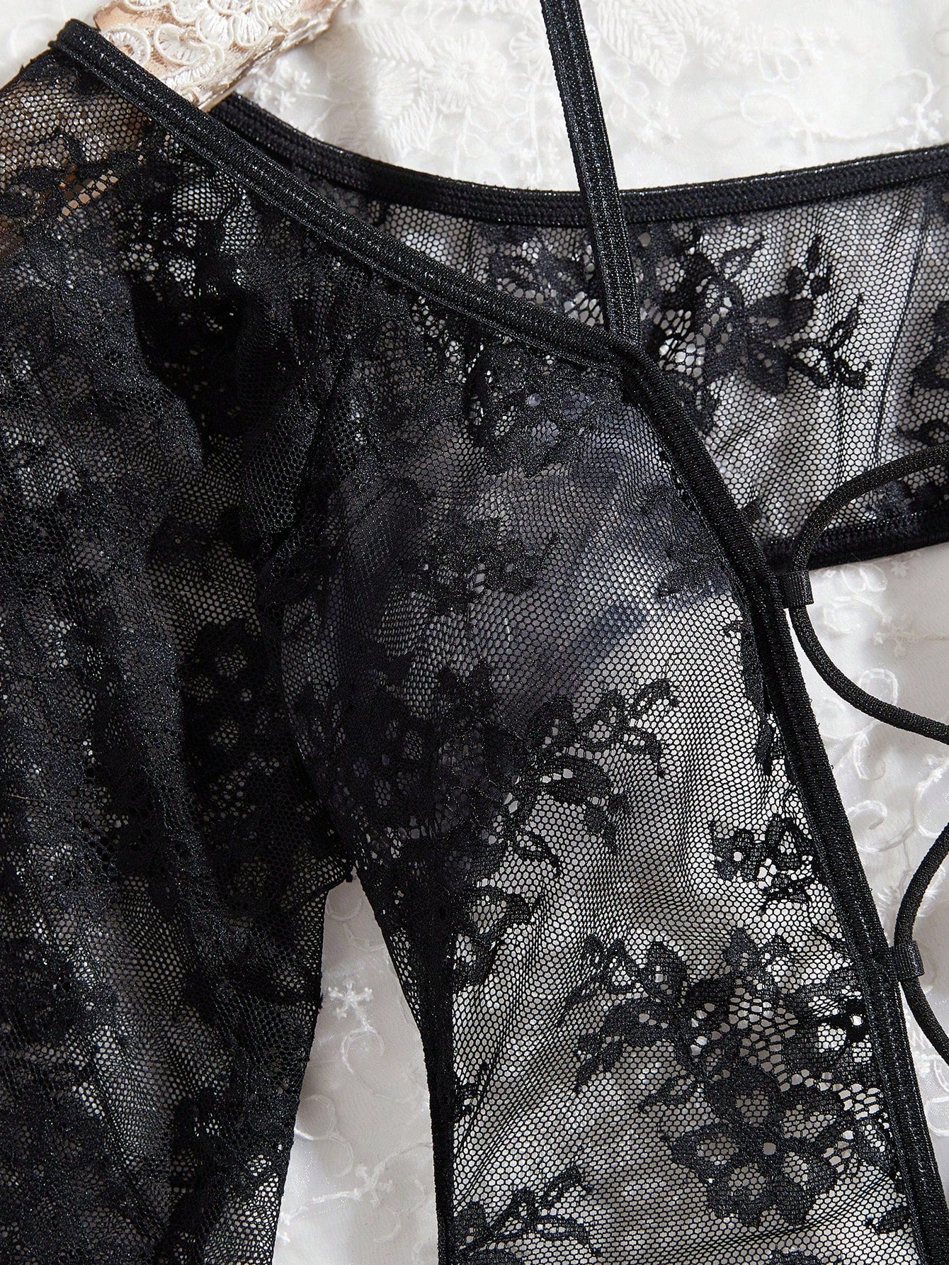Elegant lace crotchless bodysuit with a backless lace-up design, adjustable spaghetti straps, and a V-string style bottom.