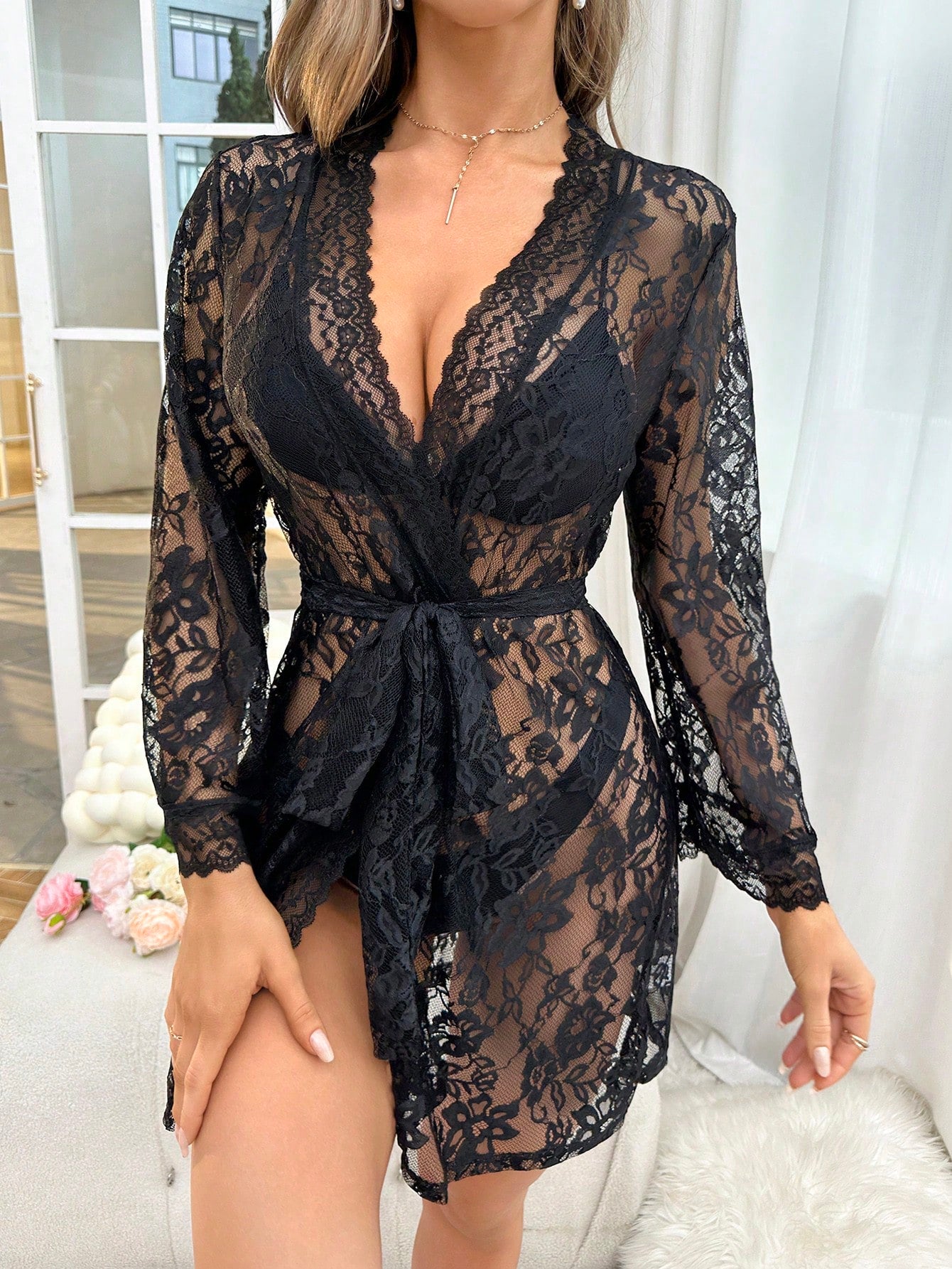 Black floral lace sheer robe with a belted waist, deep V neckline, long flare sleeves, and short length; sold without lingerie set.