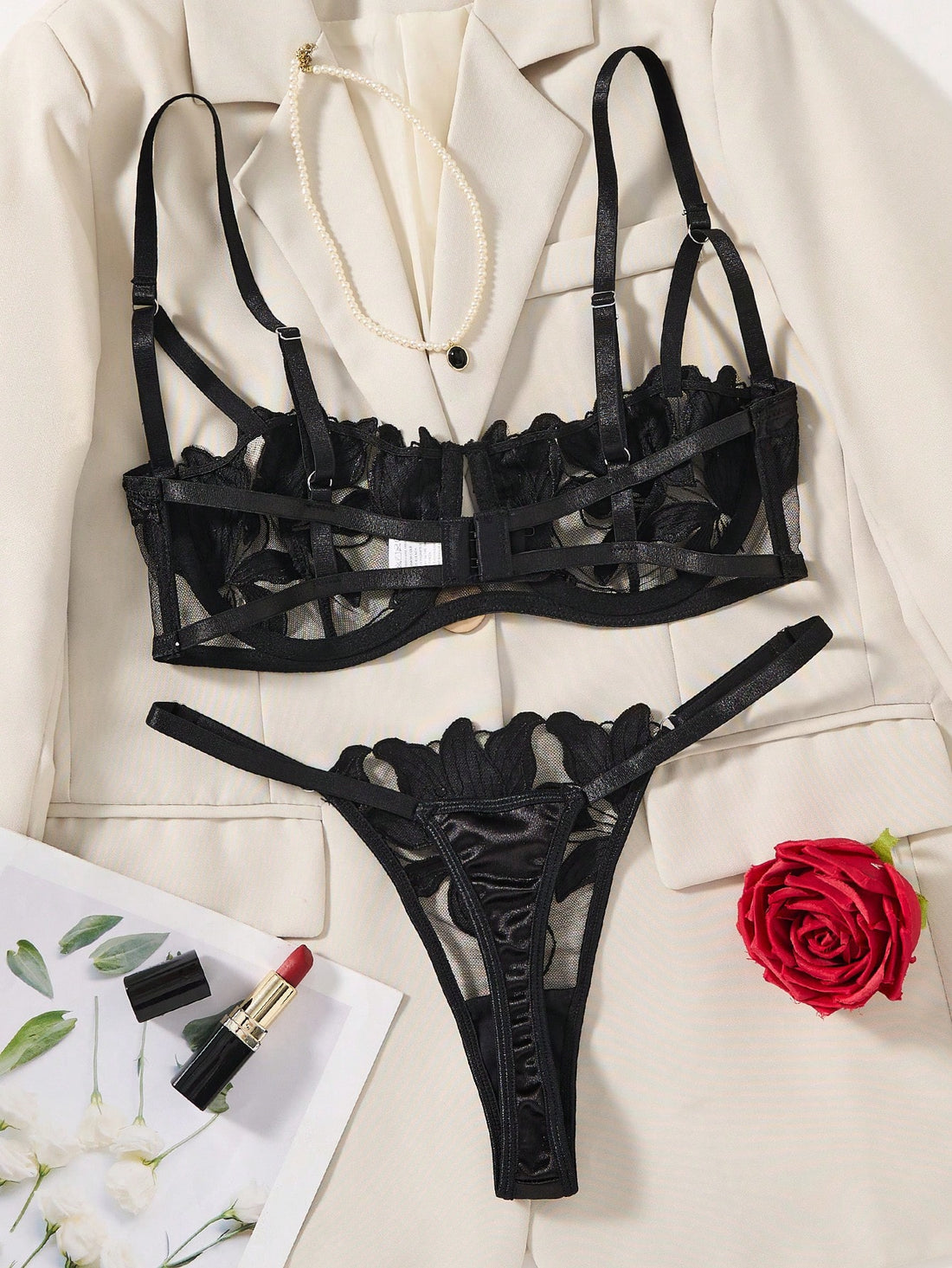 Black 2-piece lingerie set featuring a sheer maple leaf lace semi-cup underwire bra with adjustable straps and matching low-rise thong panty with embroidered floral appliques and cut-out details.