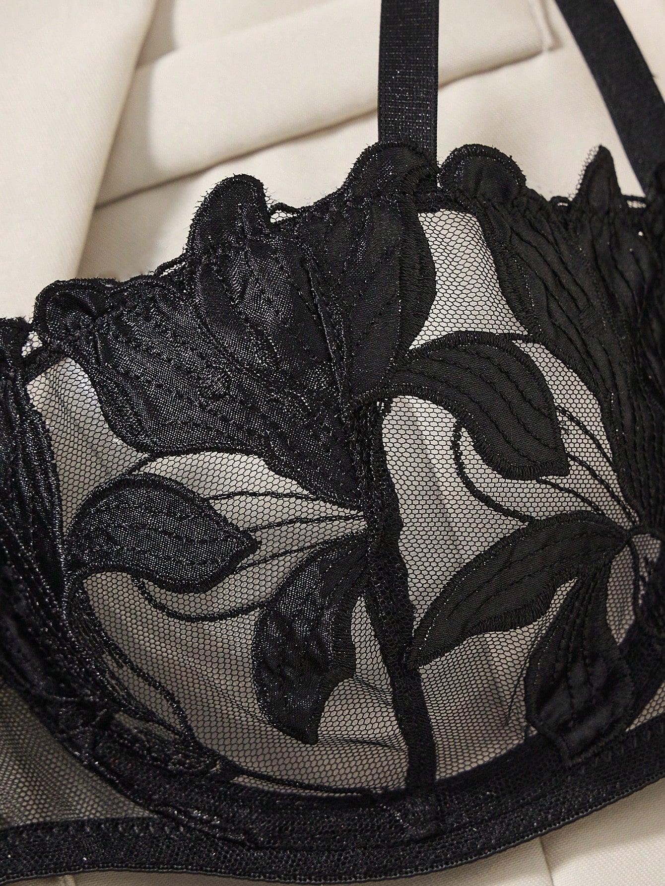 Black 2-piece lingerie set featuring a sheer maple leaf lace semi-cup underwire bra with adjustable straps and matching low-rise thong panty with embroidered floral appliques and cut-out details.