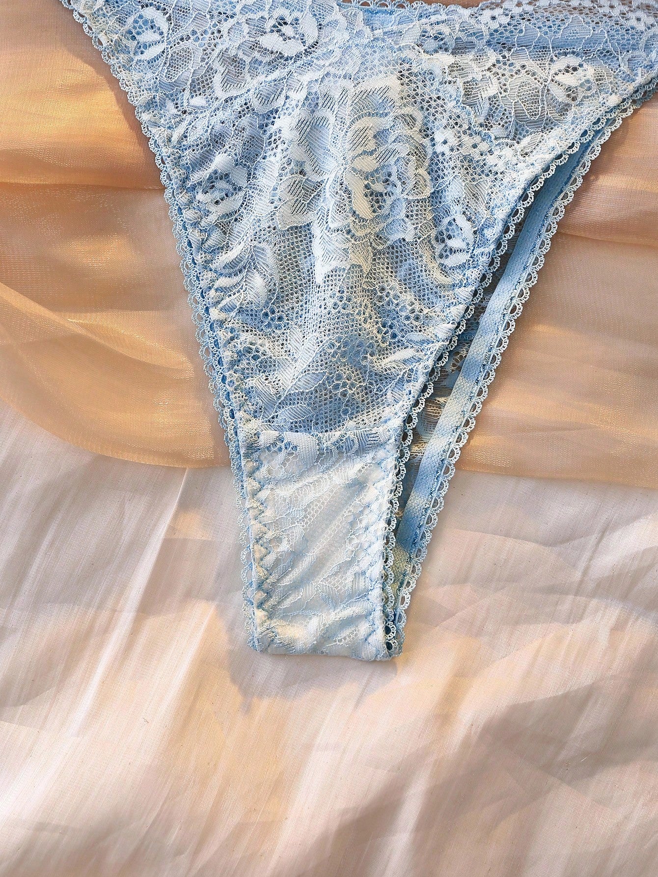 Women's floral lace lingerie set featuring a camisole-style wireless bra with adjustable straps and matching mid-rise briefs, designed with contrast scalloped lace and light support.