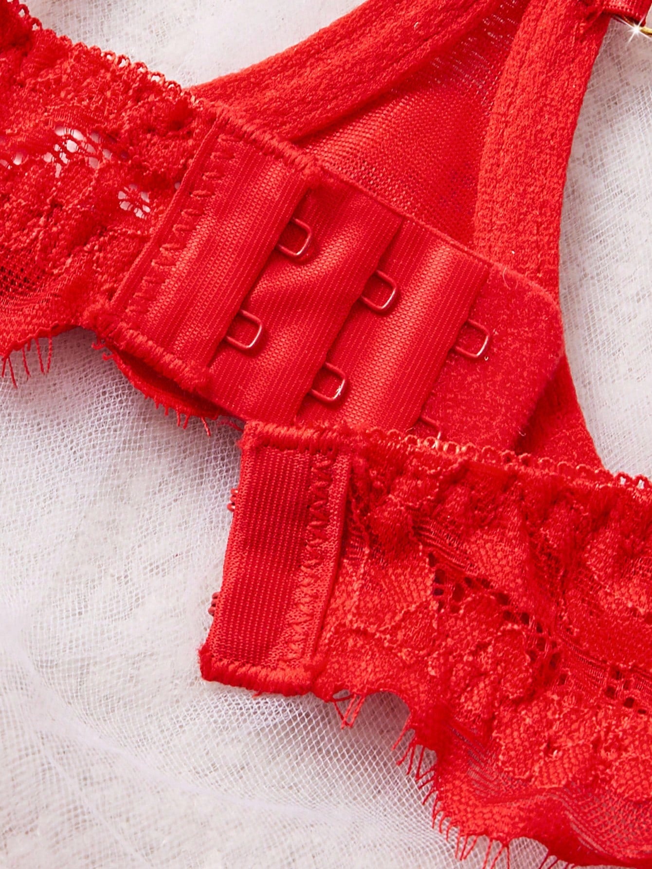 Women’s 2-piece sexy lingerie set featuring rhinestone and chain details, mesh and lace splice design, spaghetti straps, and a low-rise thong bottom; shown in black and red options.