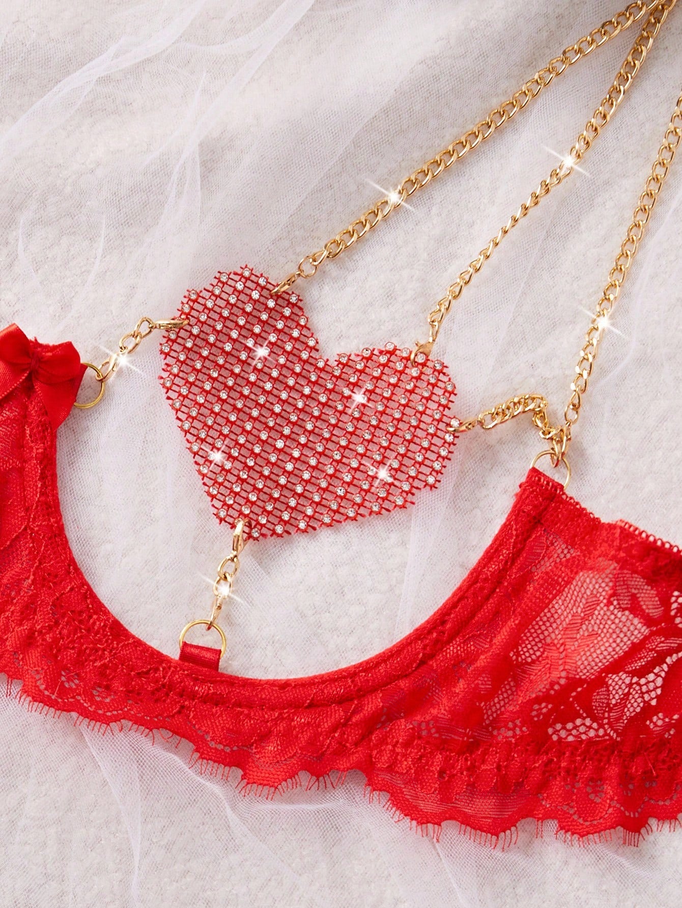 Women’s 2-piece sexy lingerie set featuring rhinestone and chain details, mesh and lace splice design, spaghetti straps, and a low-rise thong bottom; shown in black and red options.