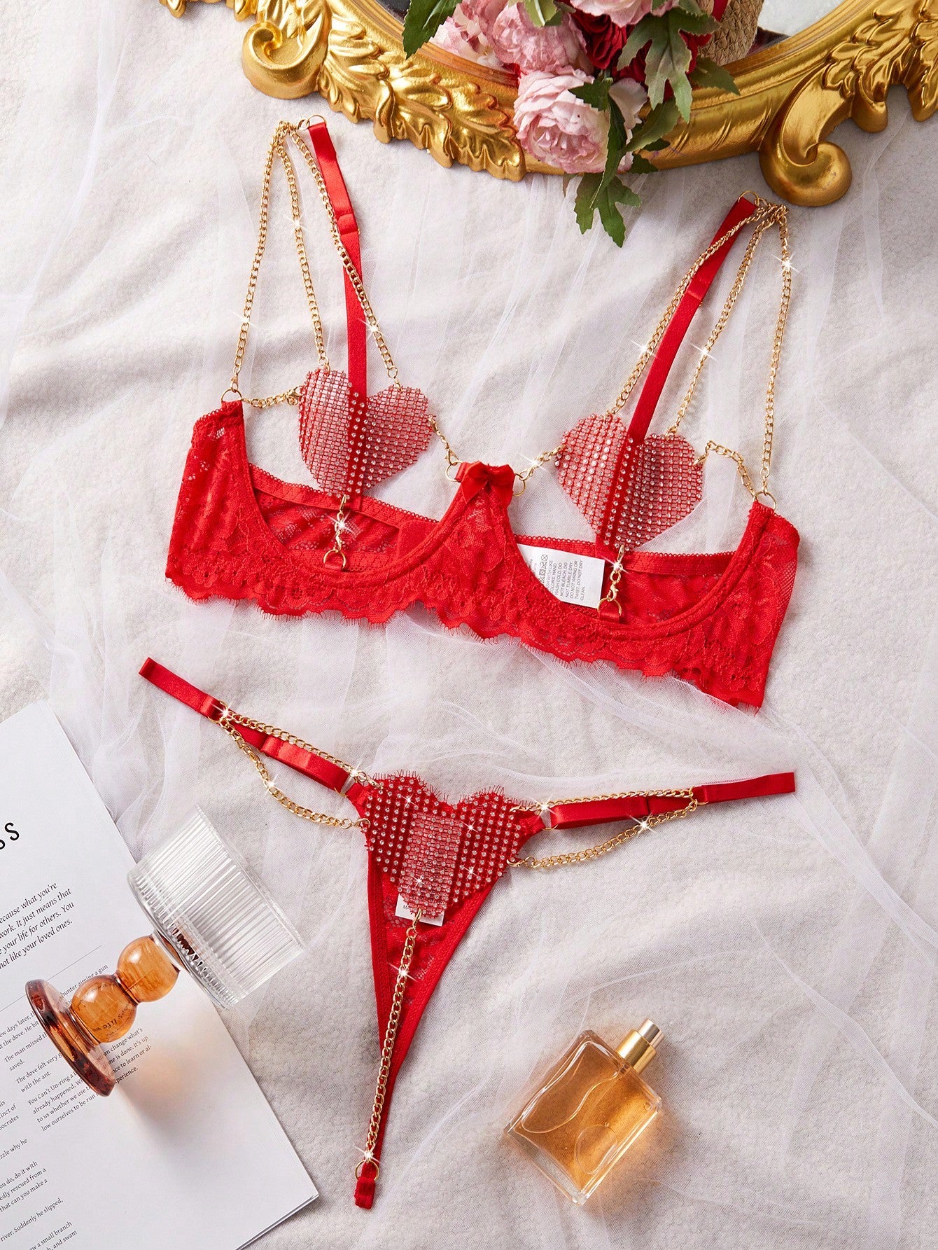 Women’s 2-piece sexy lingerie set featuring rhinestone and chain details, mesh and lace splice design, spaghetti straps, and a low-rise thong bottom; shown in black and red options.