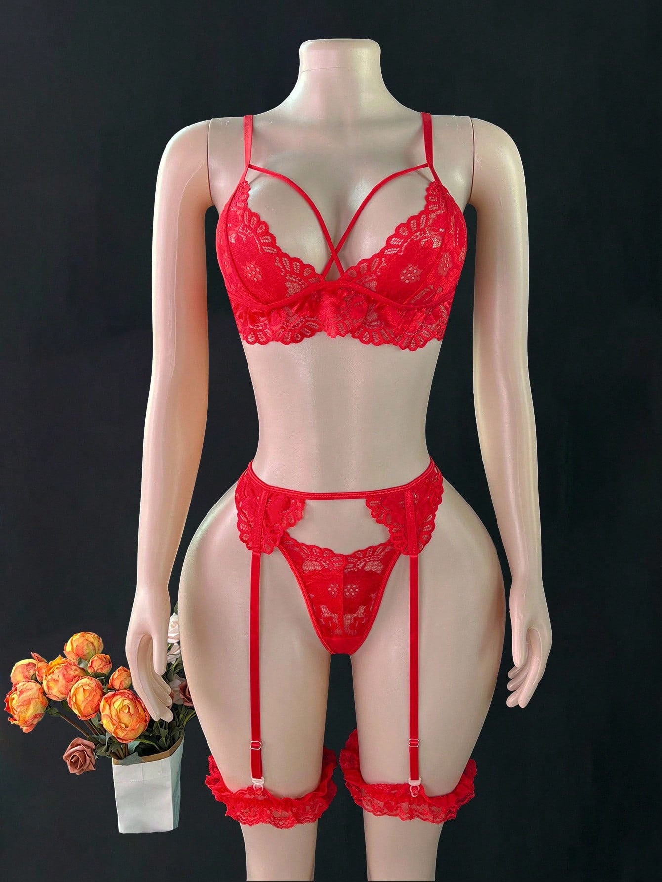 Women’s sexy lingerie set featuring a wireless bralette with adjustable spaghetti straps, matching G-string thong, garter belt, and one pair of leg rings. Plain pattern with contrast lace and criss-cross detail in a romantic style.