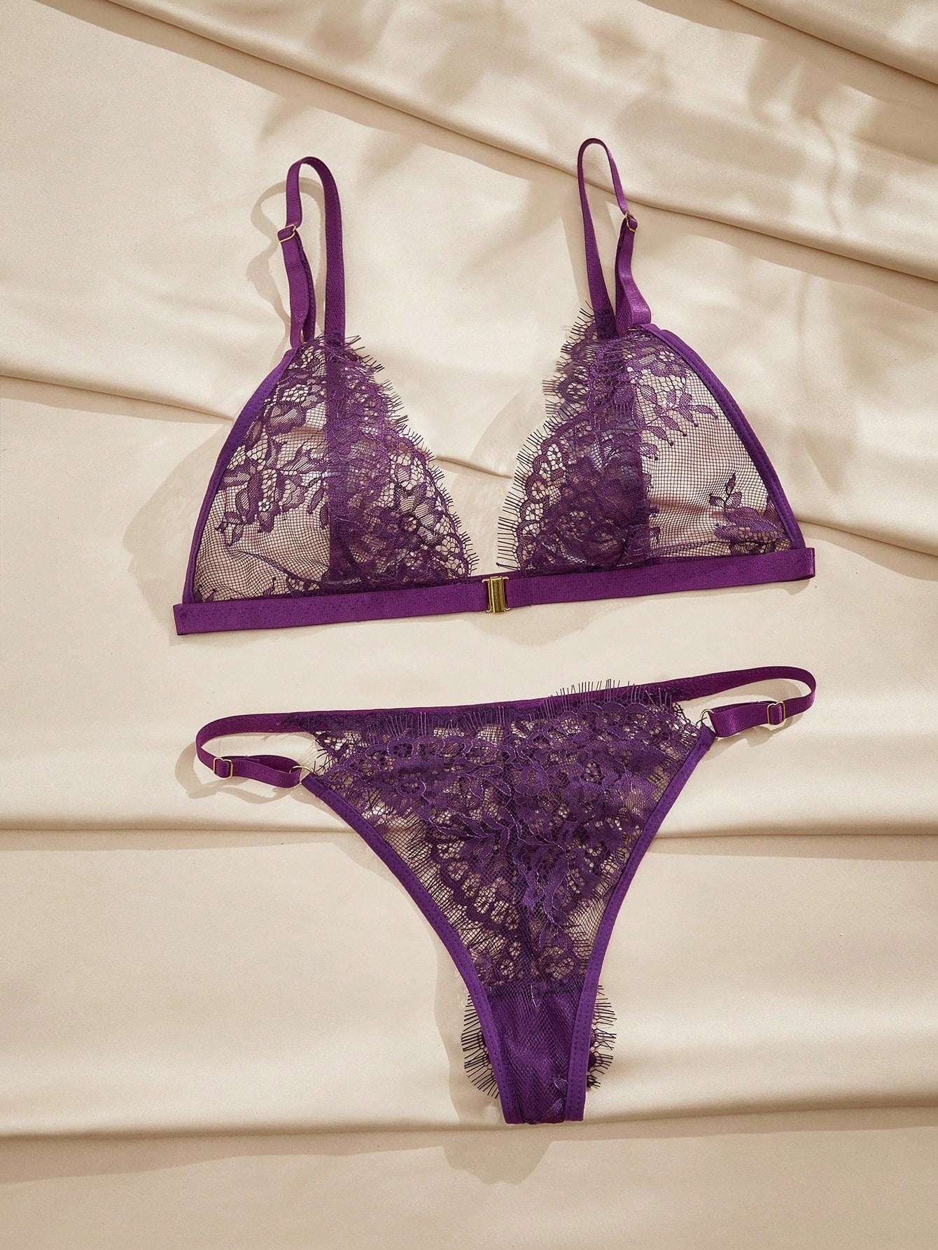 Women's purple lace lingerie set with wireless triangle bra, adjustable spaghetti straps, and matching mid-rise thong