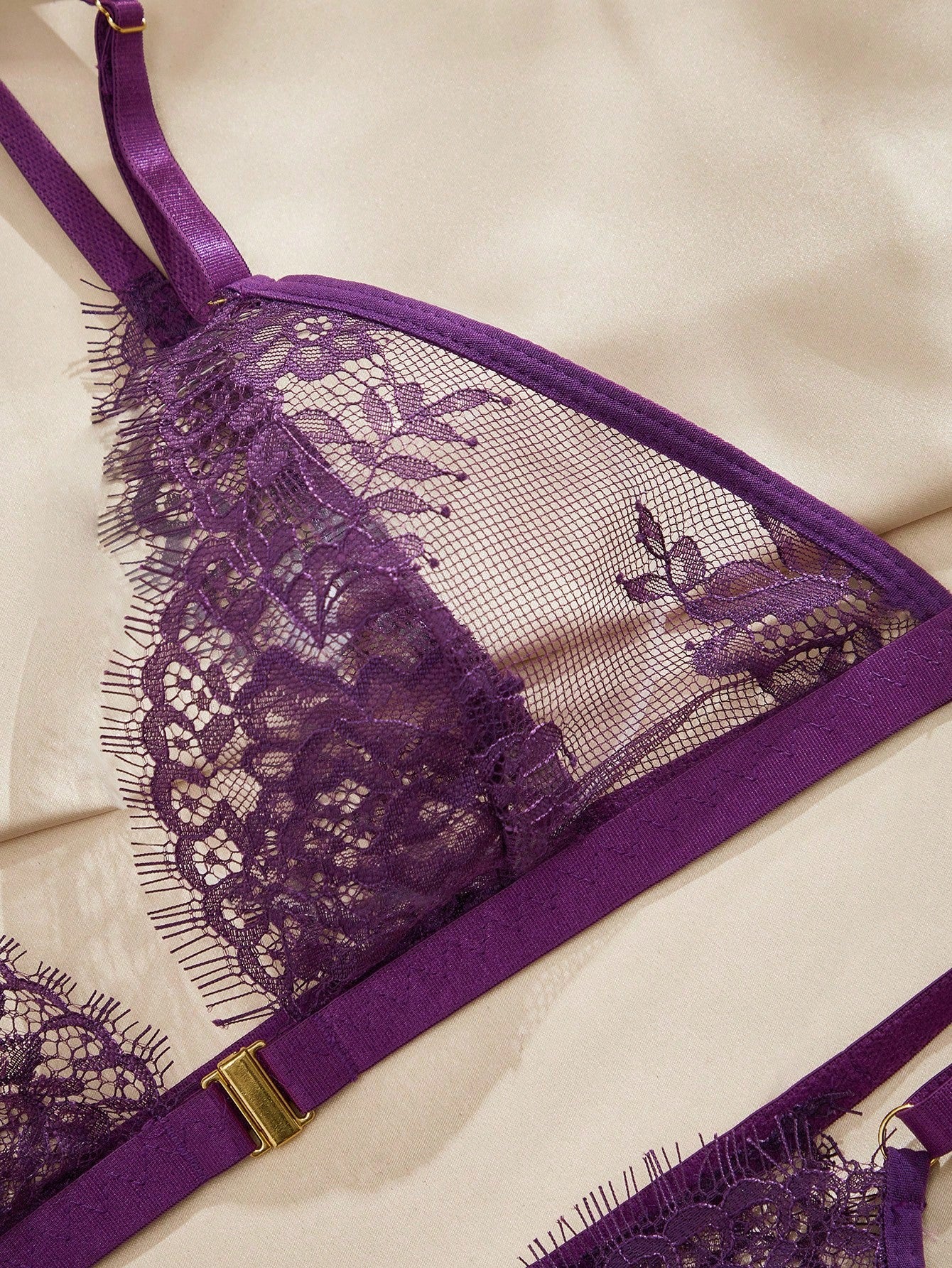 Women's purple lace lingerie set with wireless triangle bra, adjustable spaghetti straps, and matching mid-rise thong