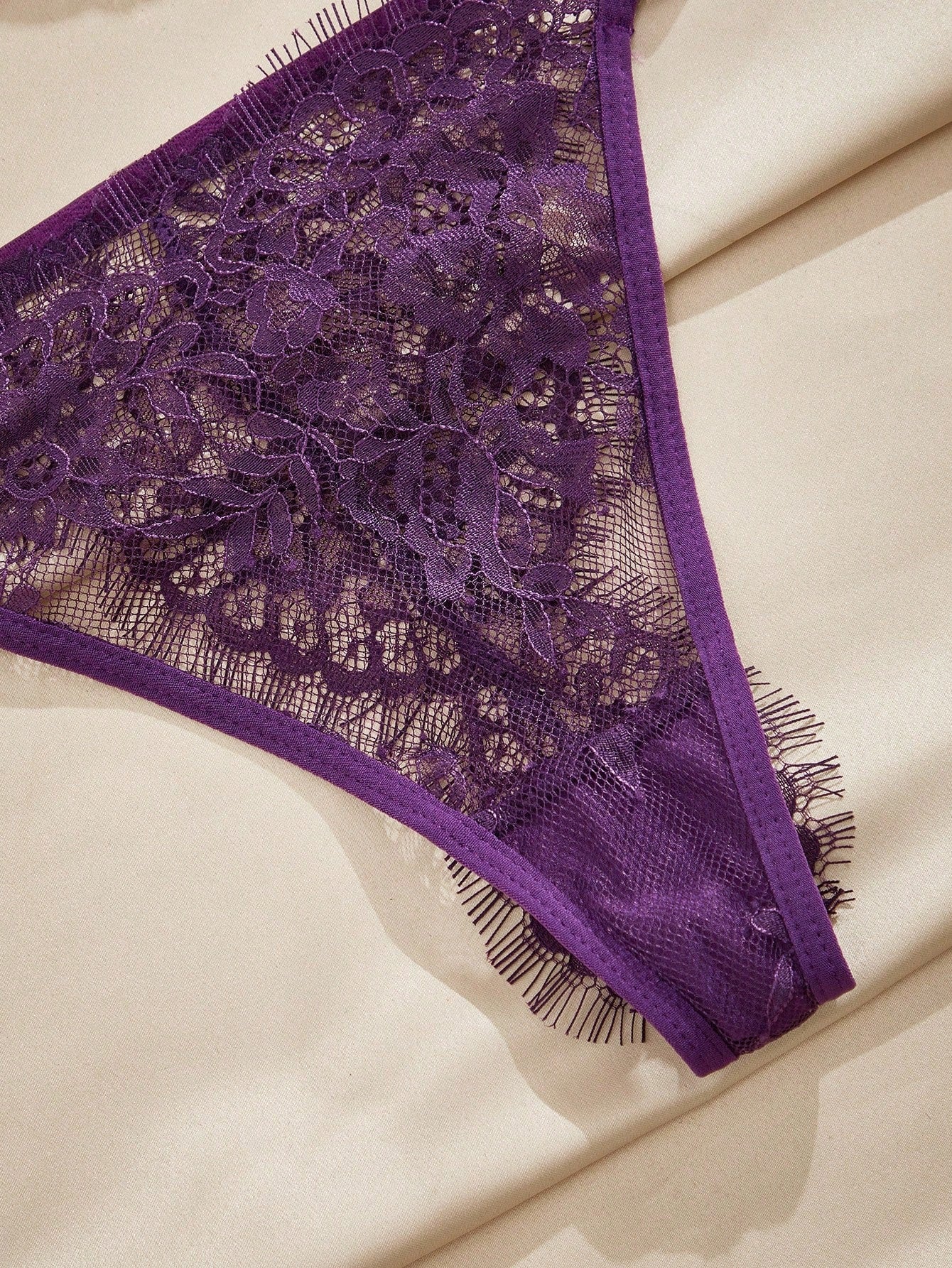 Women's purple lace lingerie set with wireless triangle bra, adjustable spaghetti straps, and matching mid-rise thong