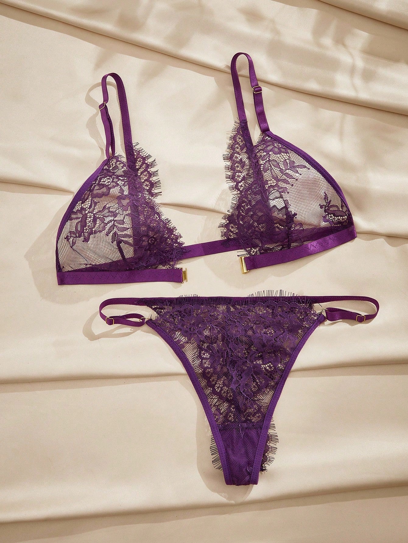 Women's purple lace lingerie set with wireless triangle bra, adjustable spaghetti straps, and matching mid-rise thong