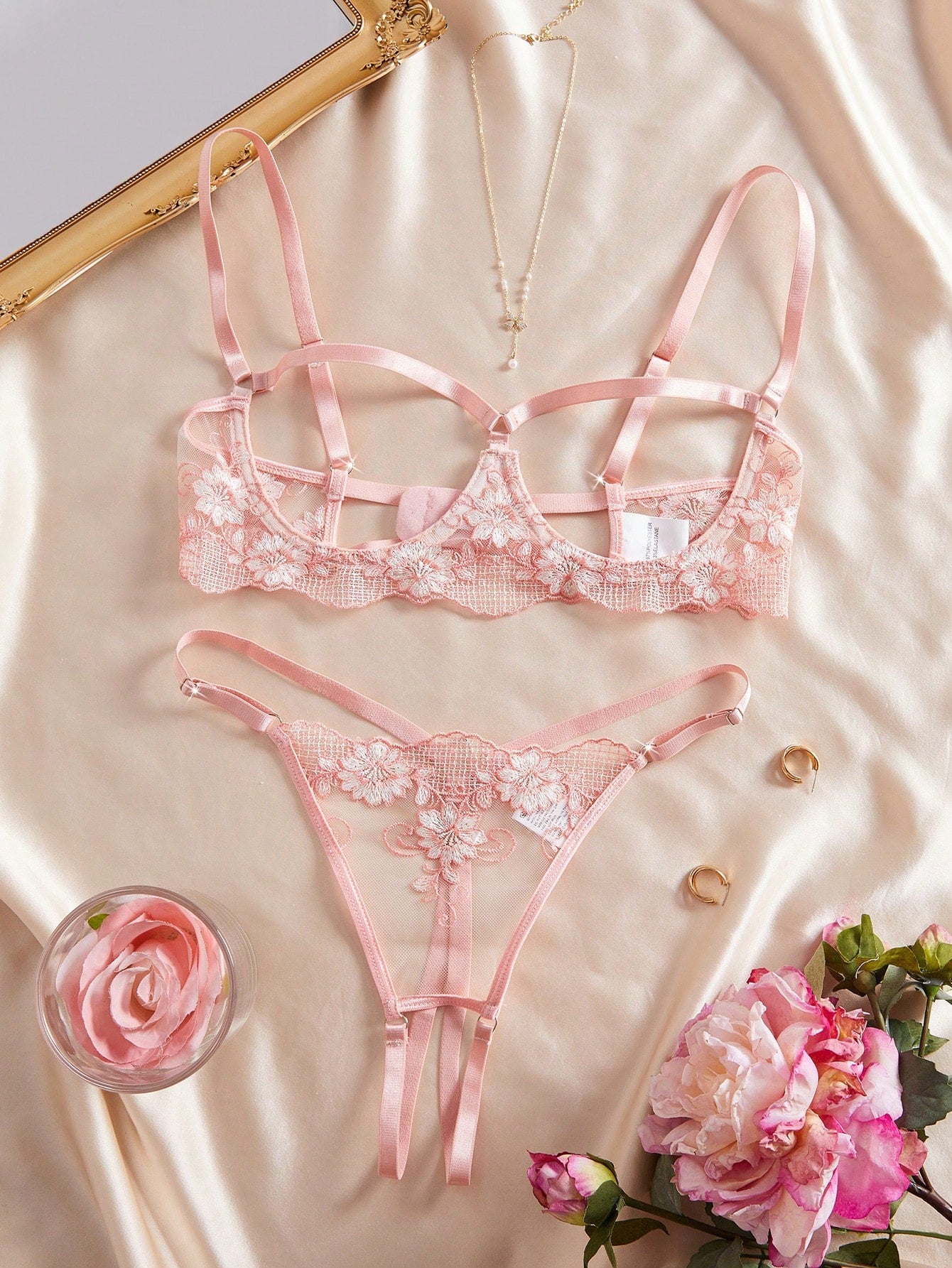 Two-piece women’s lingerie set with embroidered sheer fabric, hollow-out cutout details, underwire demi bra with adjustable spaghetti straps, and matching low-rise thong.