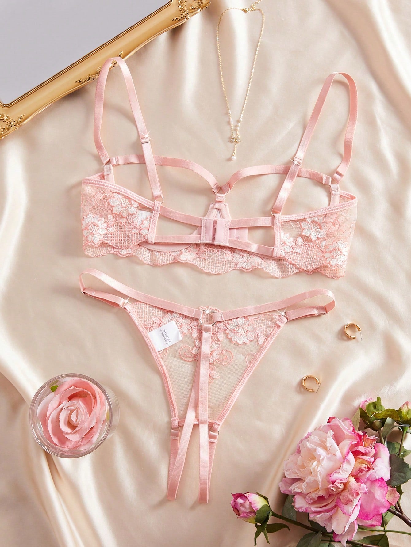 Two-piece women’s lingerie set with sheer embroidered details, cut-out accents, an underwire demi bra with adjustable spaghetti straps, and matching low-rise thong panties.