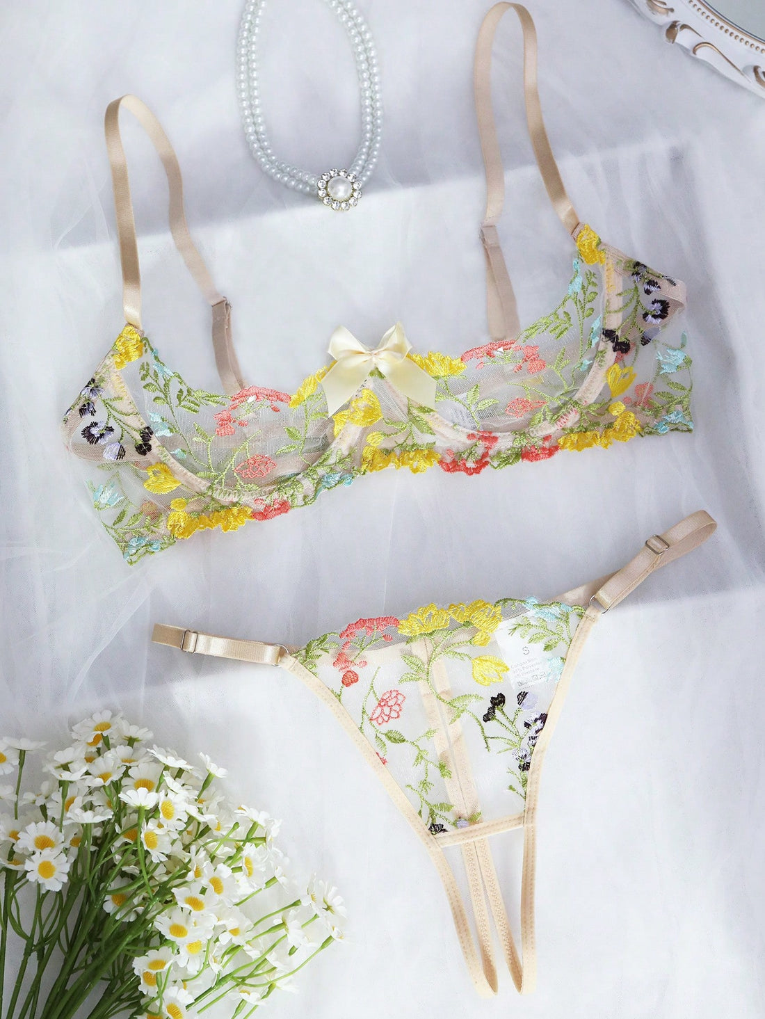 Two-piece women’s lingerie set with floral embroidery and sheer mesh, featuring an underwire spaghetti-strap top with adjustable straps and matching low-rise thong panty in a multicolor pattern.