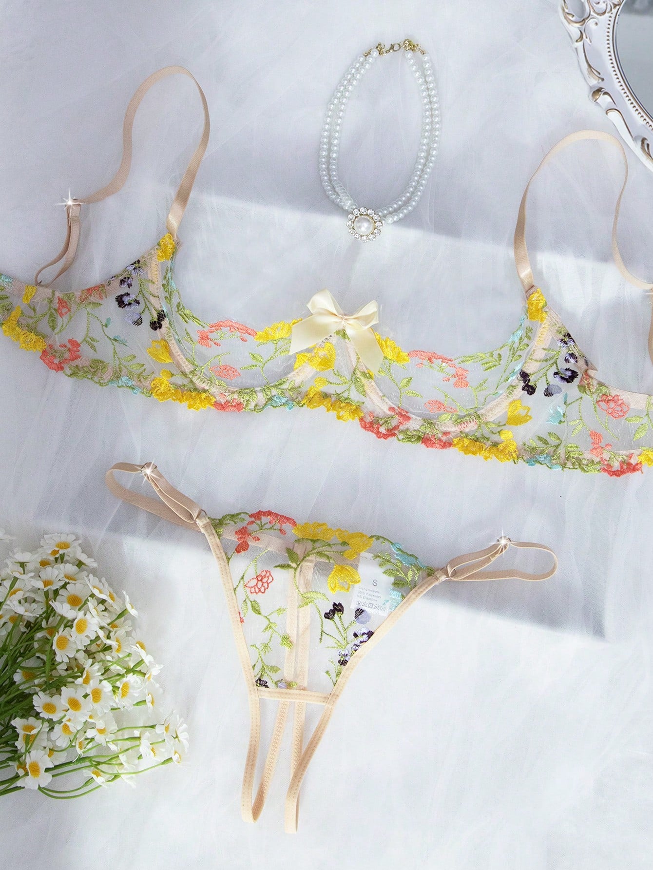 Two-piece women’s lingerie set with floral embroidery and sheer mesh, featuring an underwire spaghetti-strap top with adjustable straps and matching low-rise thong panty in a multicolor pattern.