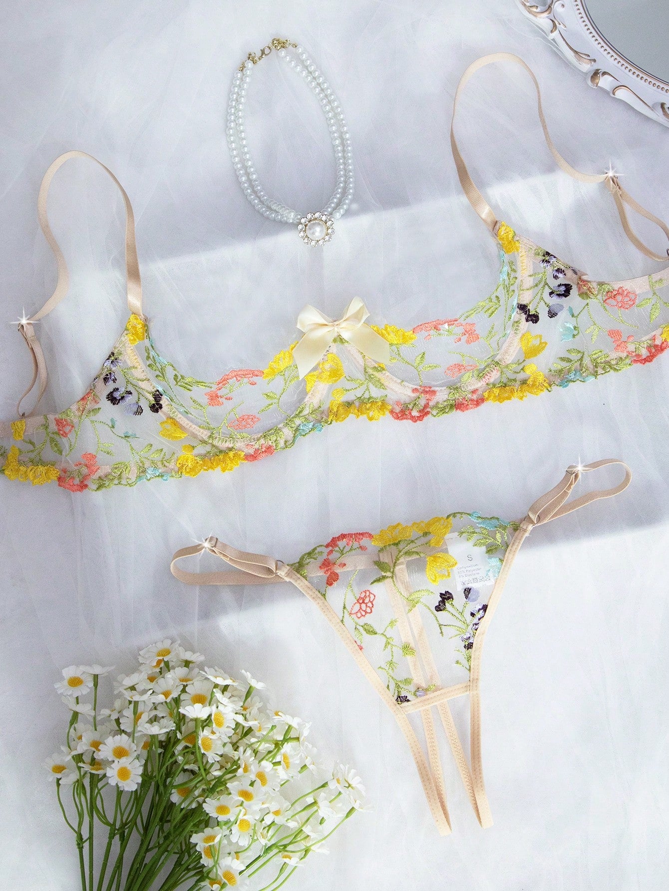 Two-piece women’s lingerie set with floral embroidery and sheer mesh, featuring an underwire spaghetti-strap top with adjustable straps and matching low-rise thong panty in a multicolor pattern.
