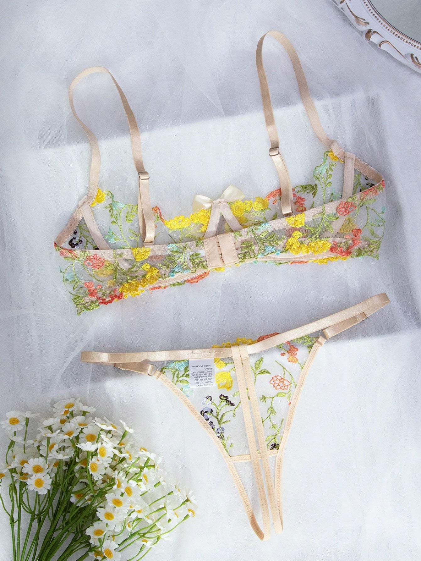 Two-piece women’s lingerie set with floral embroidery and sheer mesh, featuring an underwire spaghetti-strap top with adjustable straps and matching low-rise thong panty in a multicolor pattern.
