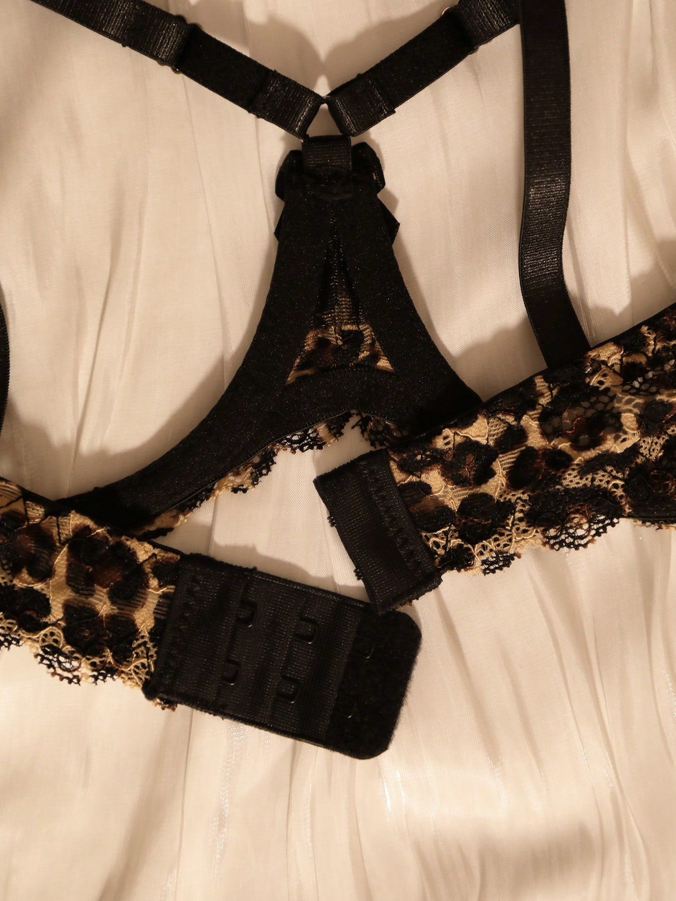 Two-piece women’s sexy lingerie set with goth leopard print, lace patchwork, mesh details, adjustable spaghetti straps, underwire top, and low-rise V-string crotchless panties.