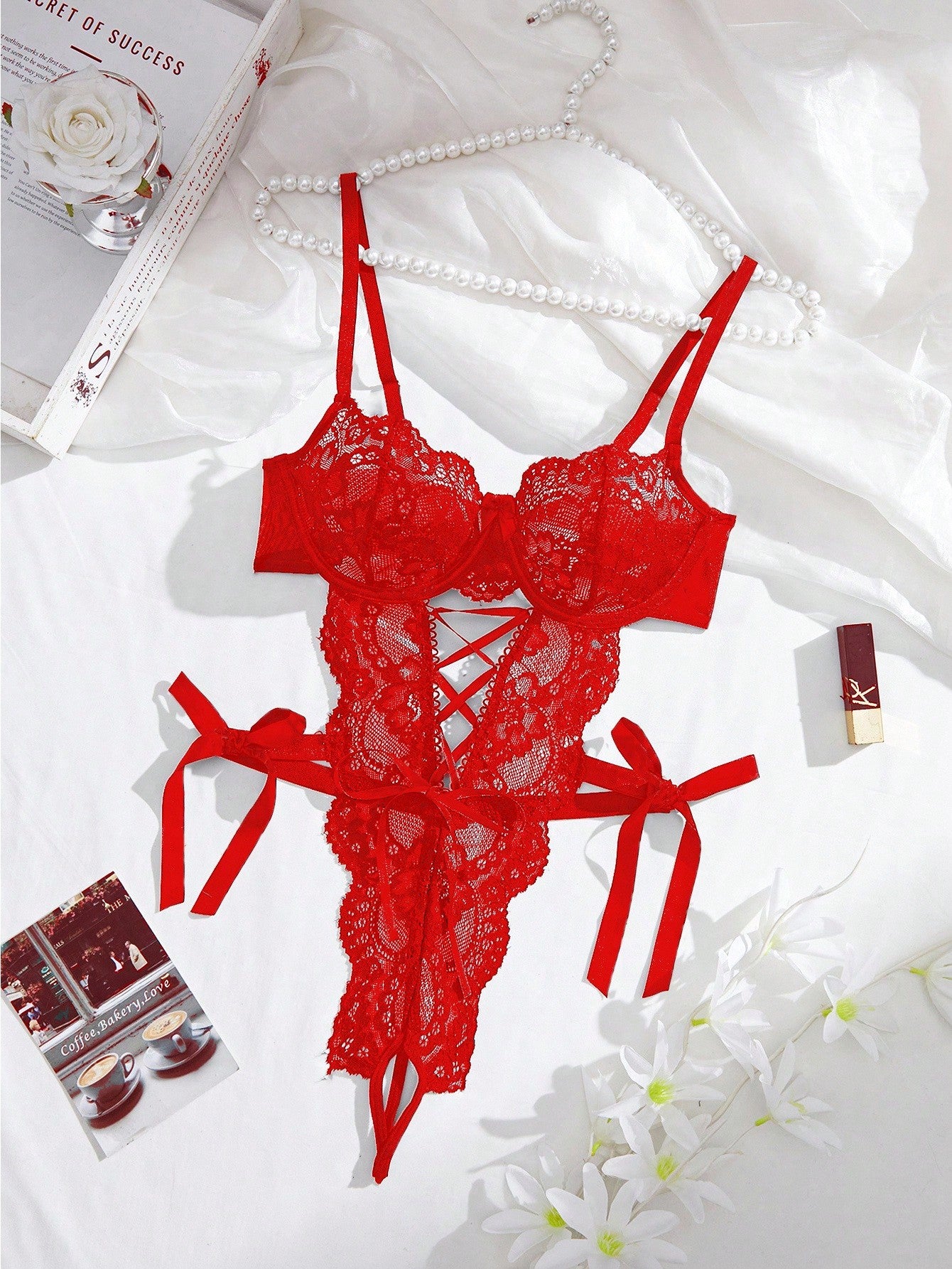 Women’s lace and mesh crotchless lingerie bodysuit with bowknot detail, cut-out accents, adjustable spaghetti straps, underwire support, and thong-style bottom.