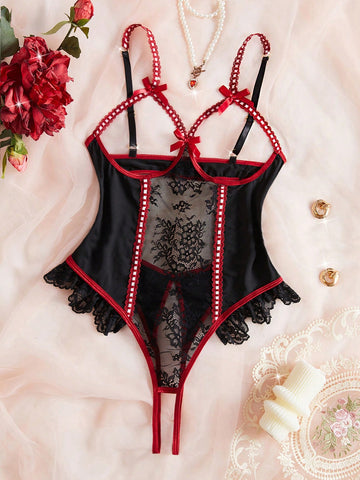 Black sheer floral lace patchwork bodysuit with adjustable spaghetti straps, bow detail, backless cut, hollow accents, and open crotch design.