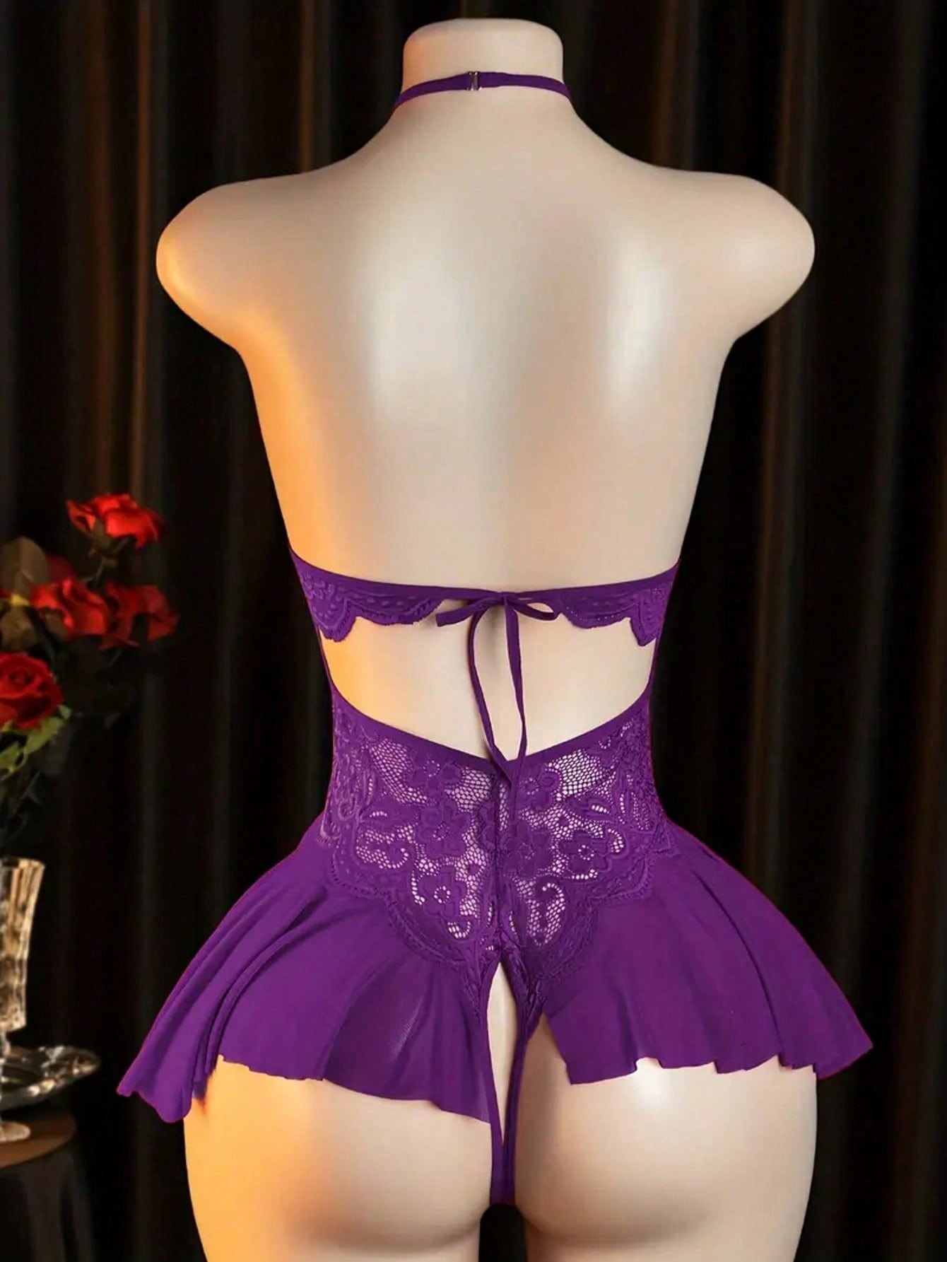 Women’s sexy lingerie bodysuit featuring an off-shoulder look, hollow-out detailing, contrast lace, sheer fabric, bow accent, halter neckline, and adjustable straps.