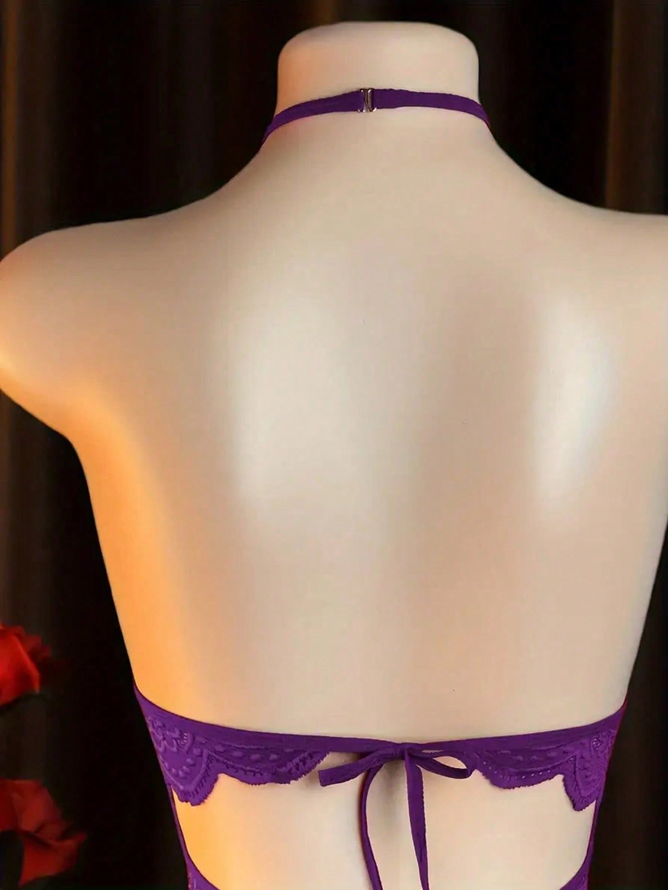 Women’s sexy lingerie bodysuit featuring an off-shoulder look, hollow-out detailing, contrast lace, sheer fabric, bow accent, halter neckline, and adjustable straps.