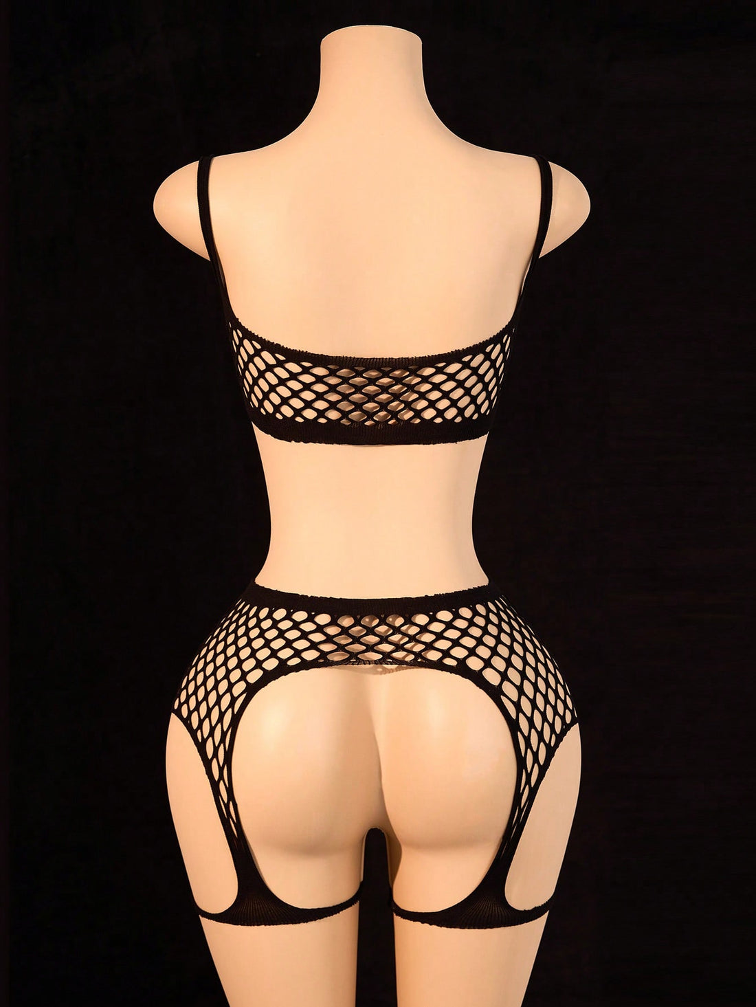 Black 2-piece fishnet lingerie set featuring a sheer wireless bralette with spaghetti straps and matching mini shorts with hollow-out detail; high-stretch fabric in a plain pattern.
