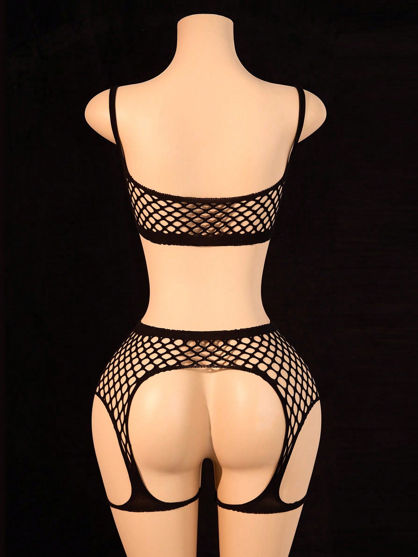 Black 2-piece fishnet lingerie set featuring a sheer wireless bralette with spaghetti straps and matching mini shorts with hollow-out detail; high-stretch fabric in a plain pattern.