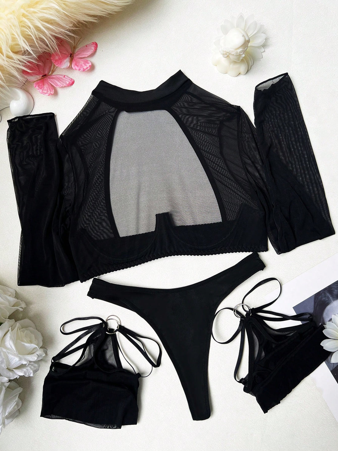 Black sheer lingerie set with a long sleeve cut-out top, thong panty, and matching stockings; includes adjustable spaghetti straps, triangle cups, underwire support, and slight stretch fabric.