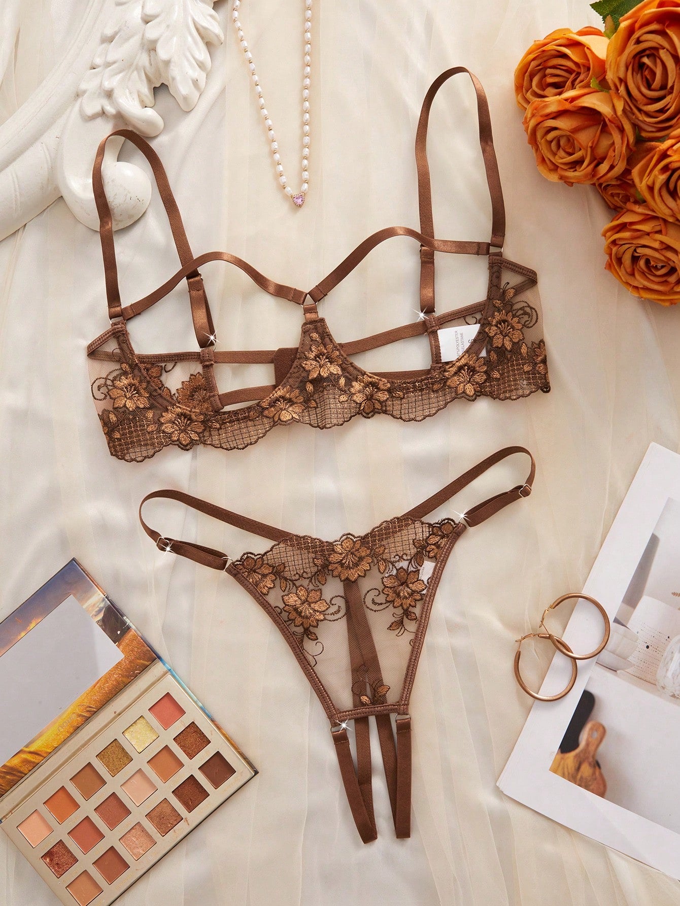 Two-piece women’s lingerie set with sheer embroidered details, cut-out accents, an underwire demi bra with adjustable spaghetti straps, and matching low-rise thong panties.
