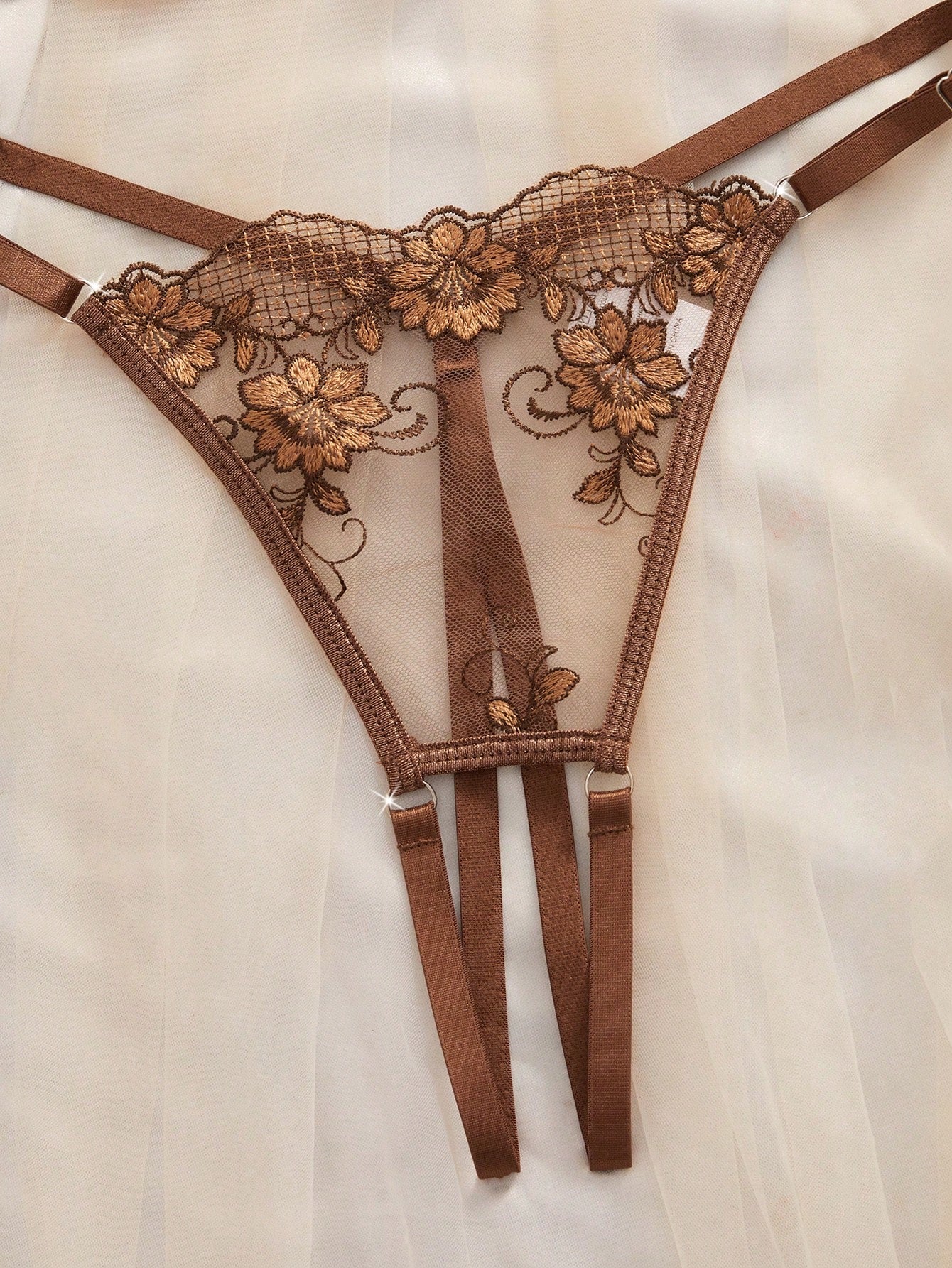 Two-piece women’s lingerie set with sheer embroidered details, cut-out accents, an underwire demi bra with adjustable spaghetti straps, and matching low-rise thong panties.