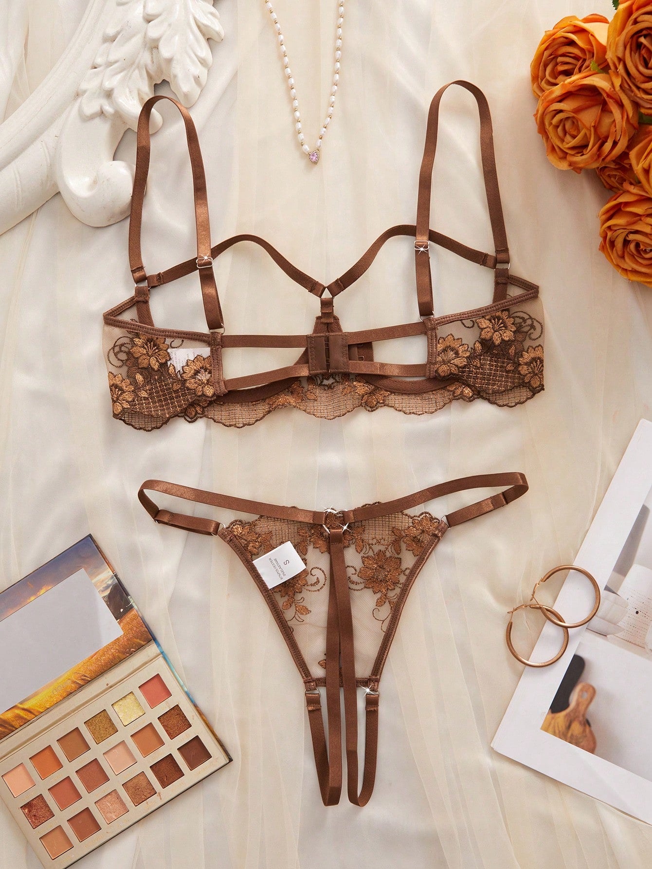 Two-piece women’s lingerie set with sheer embroidered details, cut-out accents, an underwire demi bra with adjustable spaghetti straps, and matching low-rise thong panties.