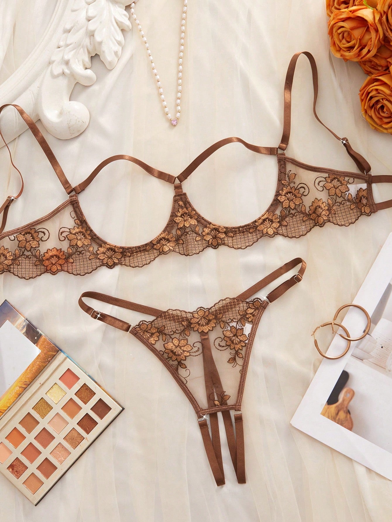 Two-piece women’s lingerie set with sheer embroidered details, cut-out accents, an underwire demi bra with adjustable spaghetti straps, and matching low-rise thong panties.