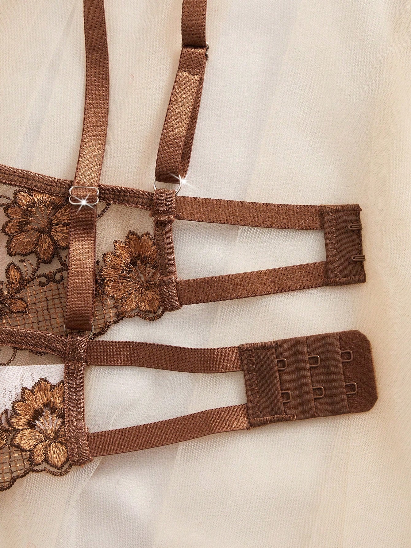 Two-piece women’s lingerie set with sheer embroidered details, cut-out accents, an underwire demi bra with adjustable spaghetti straps, and matching low-rise thong panties.