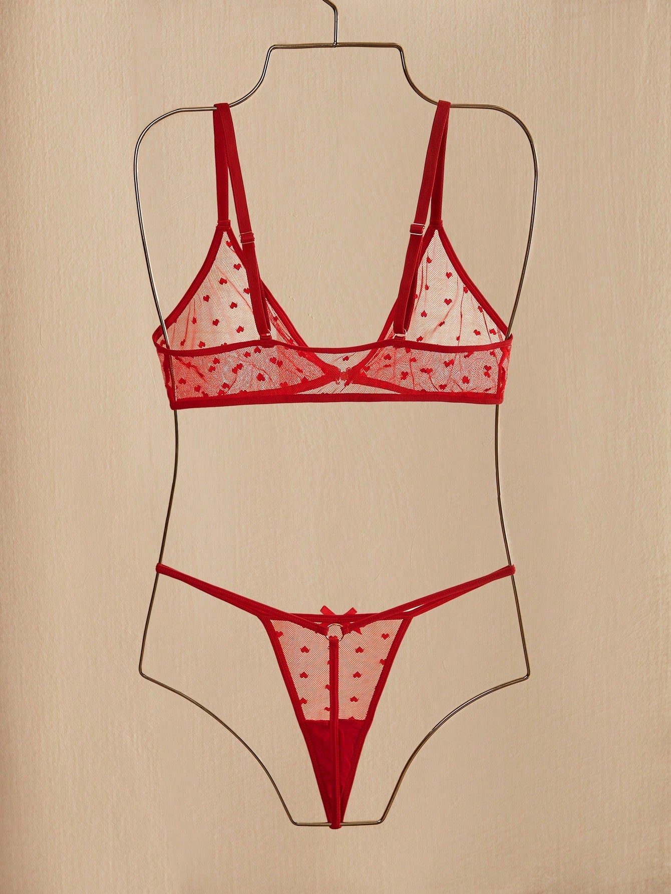 Women's heart mesh lingerie set with sheer plant pattern and bow detail, featuring a wireless bralette with adjustable straps and a matching low-rise thong.