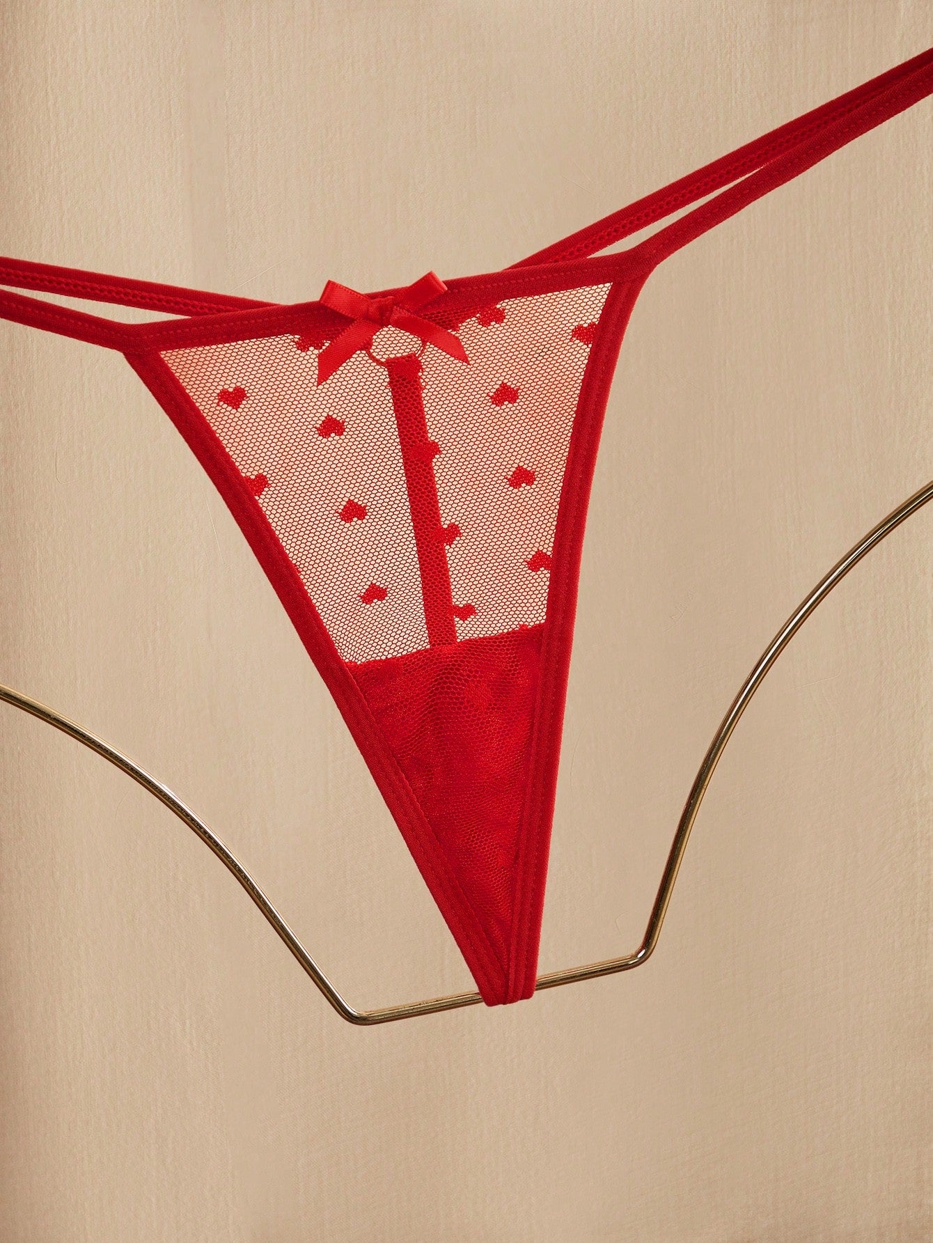 Women's heart mesh lingerie set with sheer plant pattern and bow detail, featuring a wireless bralette with adjustable straps and a matching low-rise thong.