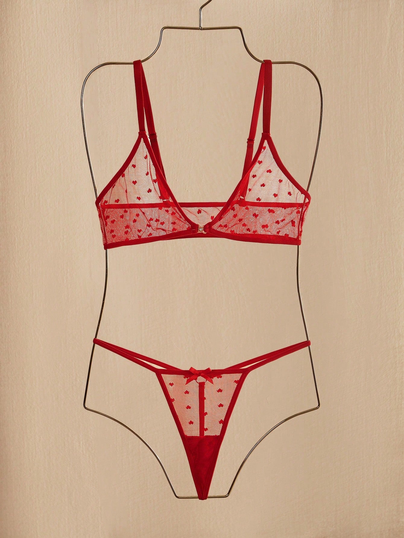 Women's heart mesh lingerie set with sheer plant pattern and bow detail, featuring a wireless bralette with adjustable straps and a matching low-rise thong.