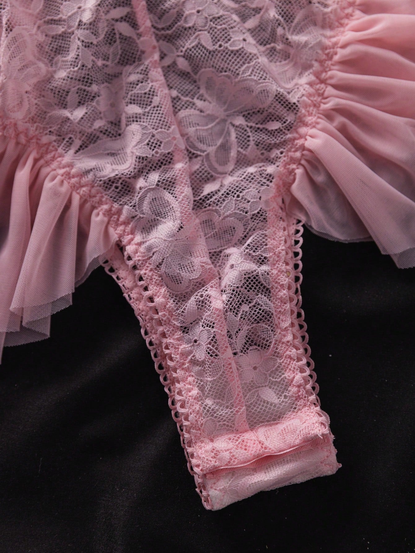 Women’s butterfly lace and mesh lingerie jumpsuit with ruffled trim, underwire cups, bow detail, cut-out accents, sheer fabric, and adjustable spaghetti straps.