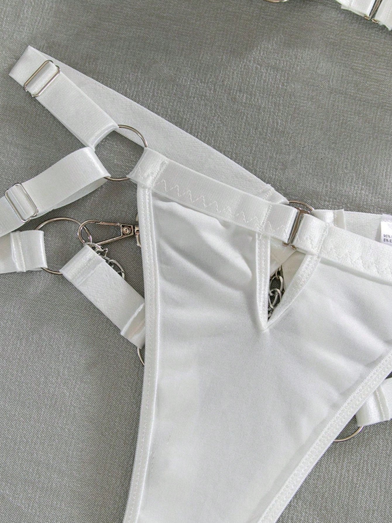 White tie-dye 2-piece backless lingerie set with spaghetti straps, cut-out ring and chain details, and mid-rise crotchless brief panties.