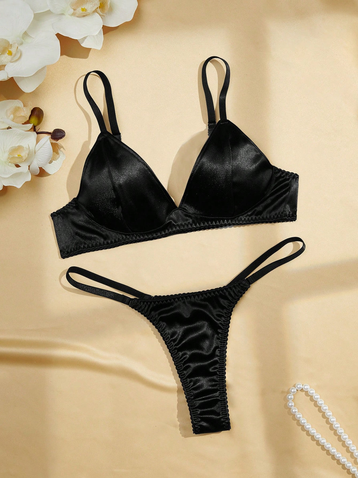 Black 2-piece lingerie set with a wireless bralette featuring adjustable straps and matching low-rise thong