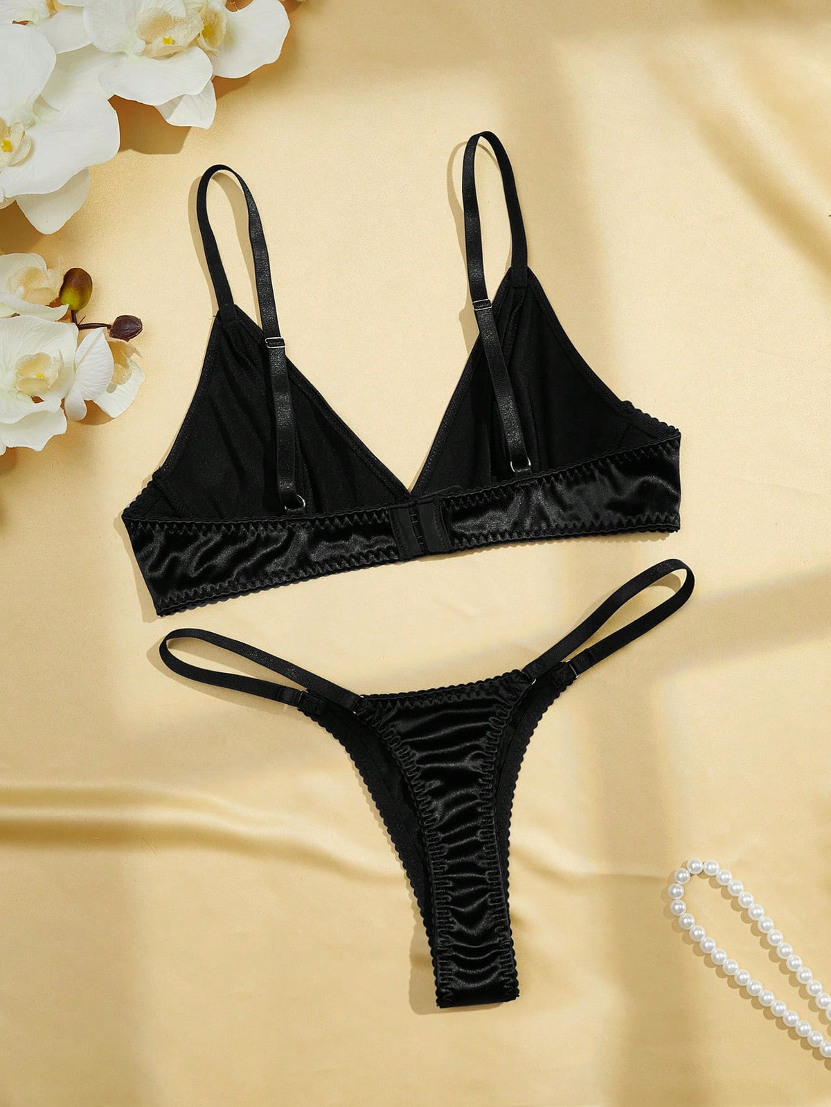 Black 2-piece lingerie set with a wireless bralette featuring adjustable straps and matching low-rise thong