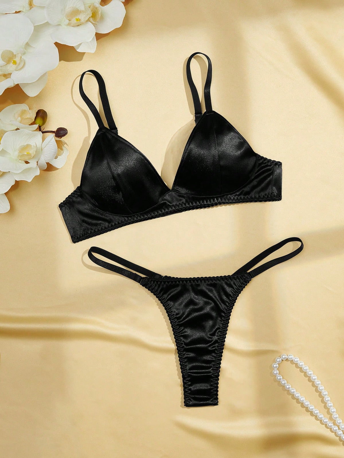 Black 2-piece lingerie set with a wireless bralette featuring adjustable straps and matching low-rise thong