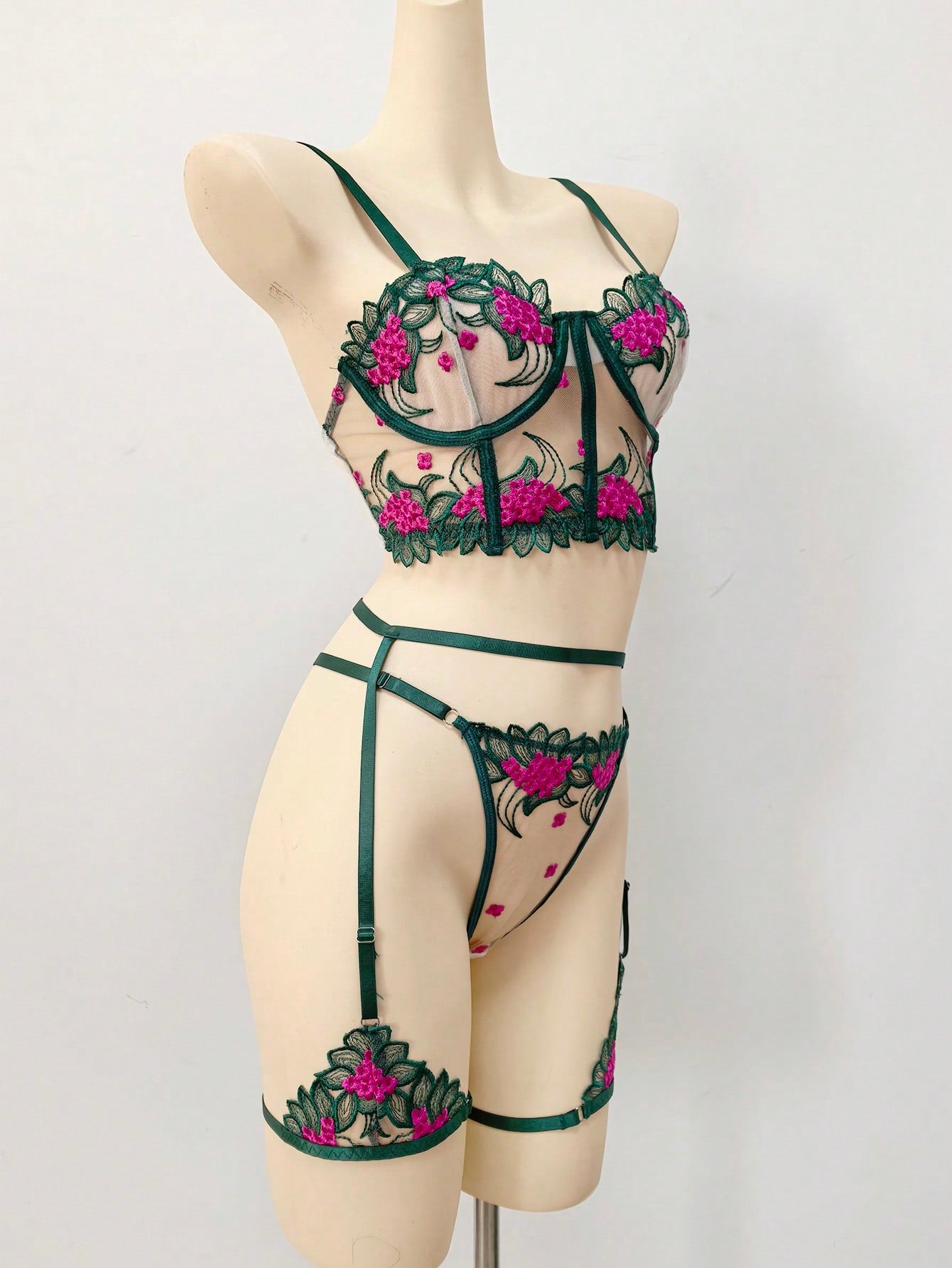 Three-piece women’s lingerie set with floral embroidery and sheer hollow-out design, featuring a longline spaghetti-strap bra with adjustable straps and matching low-rise thong style pieces.