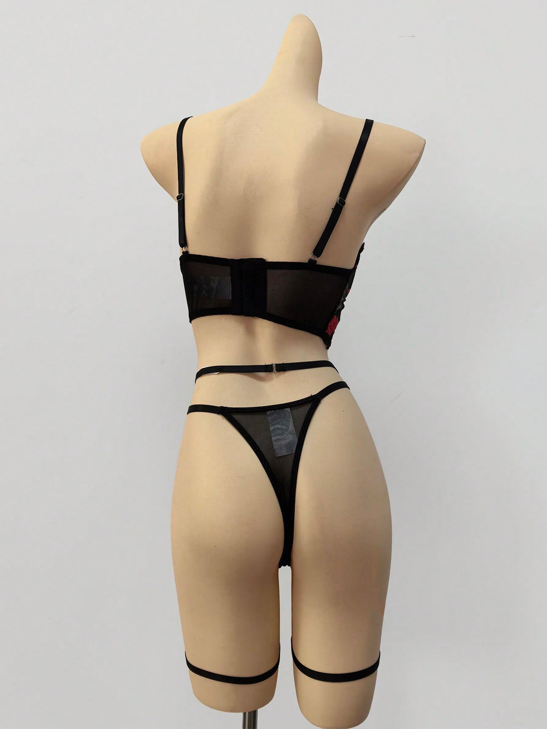 Three-piece women’s lingerie set with floral embroidery and sheer hollow-out design, featuring a longline spaghetti-strap bra with adjustable straps and matching low-rise thong style pieces.