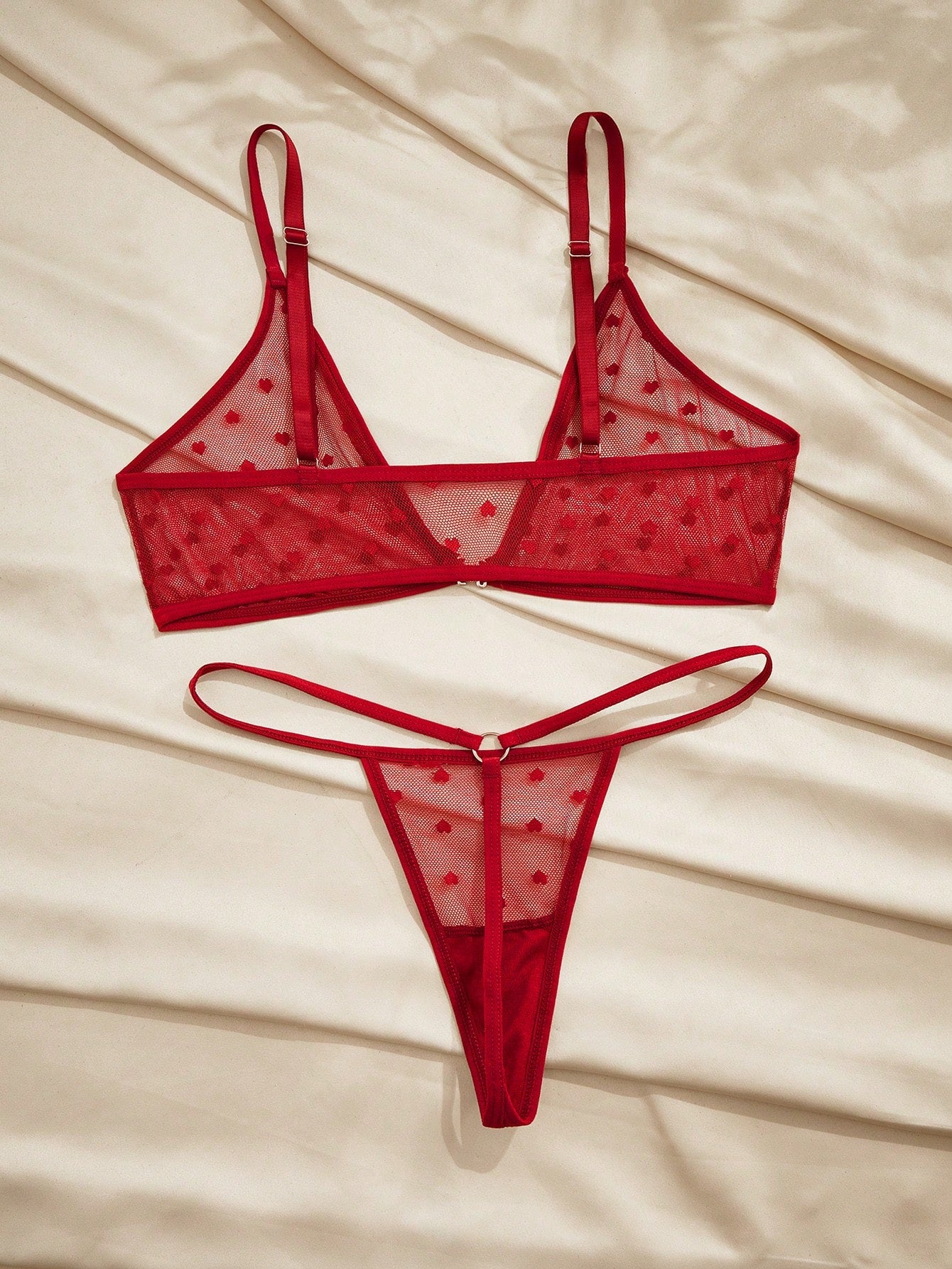 Women's heart mesh lingerie set with sheer plant pattern and bow detail, featuring a wireless bralette with adjustable straps and a matching low-rise thong.