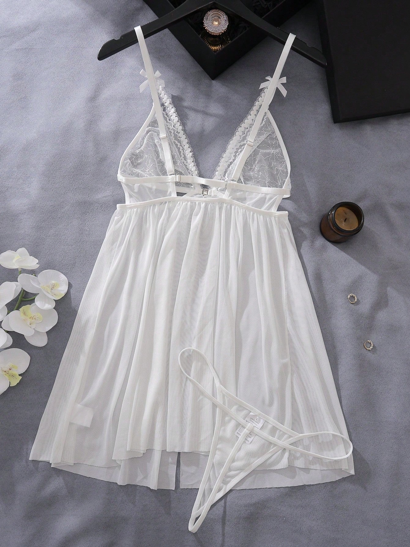 Women’s 2-piece lingerie set featuring a romantic lace patchwork babydoll nightgown with spaghetti straps, bow and cut-out details, and a matching low-rise thong.