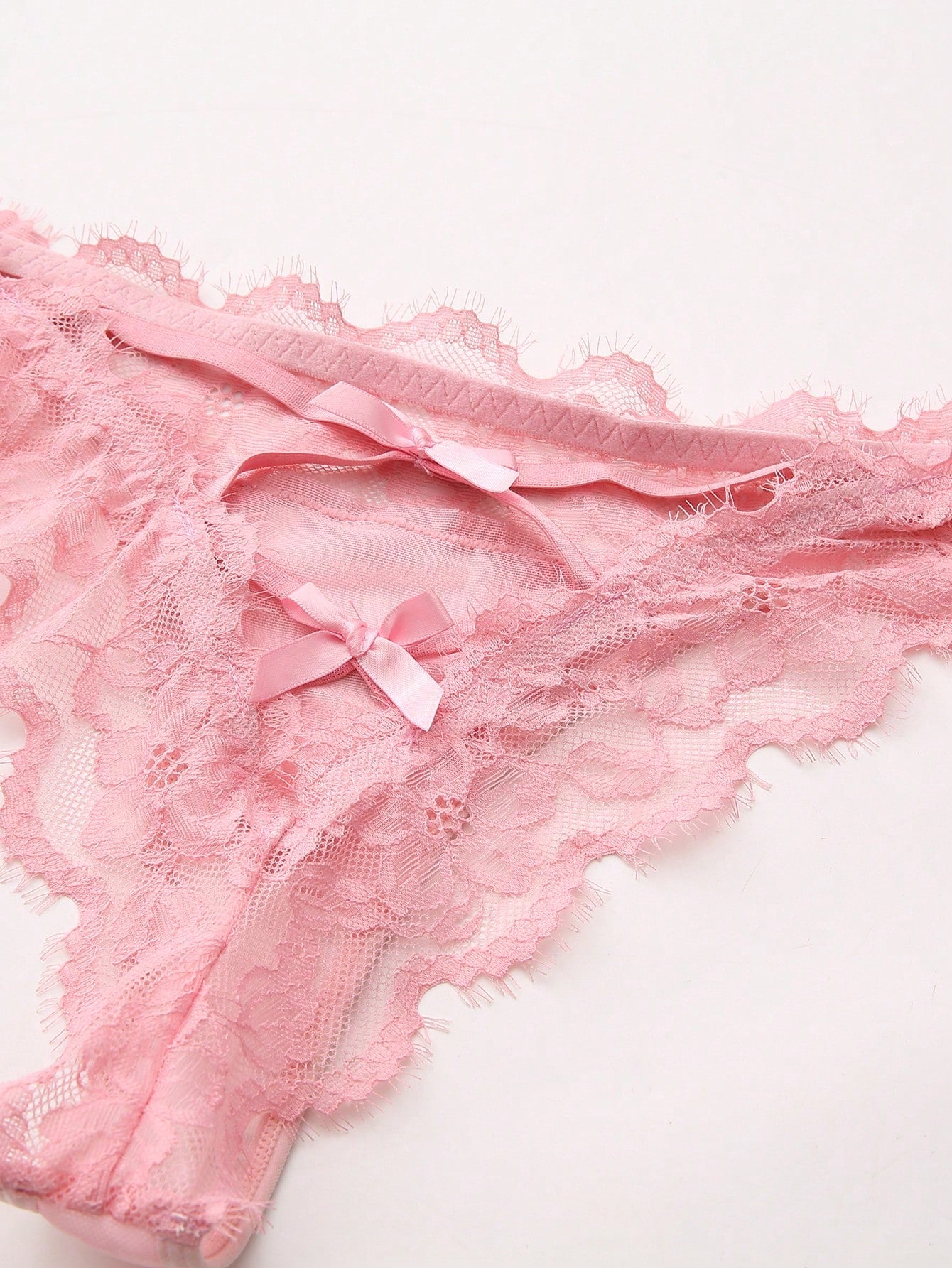 Women's low-rise lace mesh trim thong panties with sheer detailing, bow and knot accents, and plant pattern