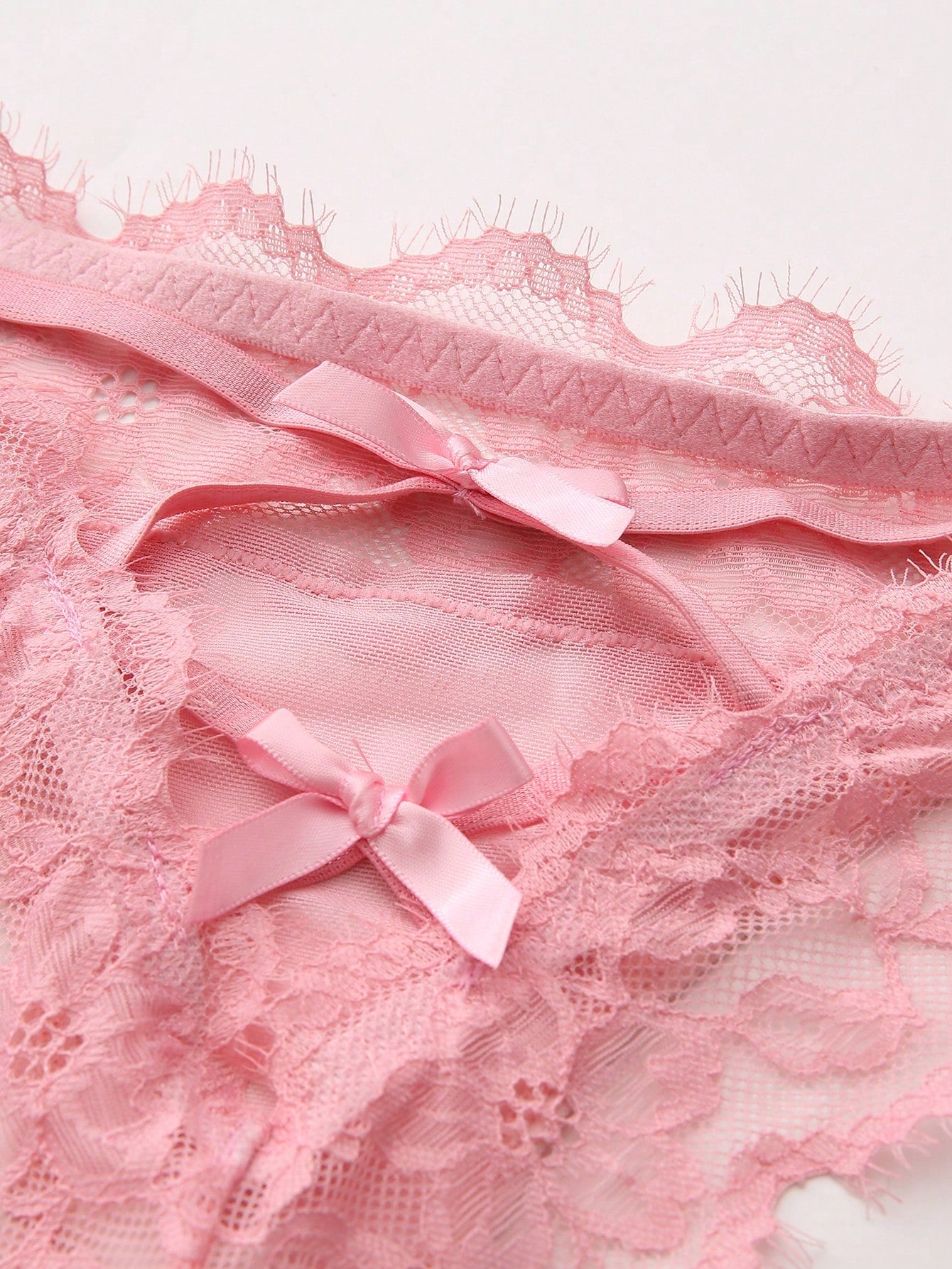 Women's low-rise lace mesh trim thong panties with sheer detailing, bow and knot accents, and plant pattern