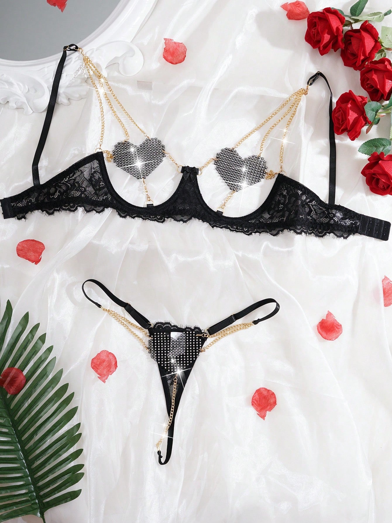 Women’s 2-piece sexy lingerie set featuring rhinestone and chain details, mesh and lace splice design, spaghetti straps, and a low-rise thong bottom; shown in black and red options.