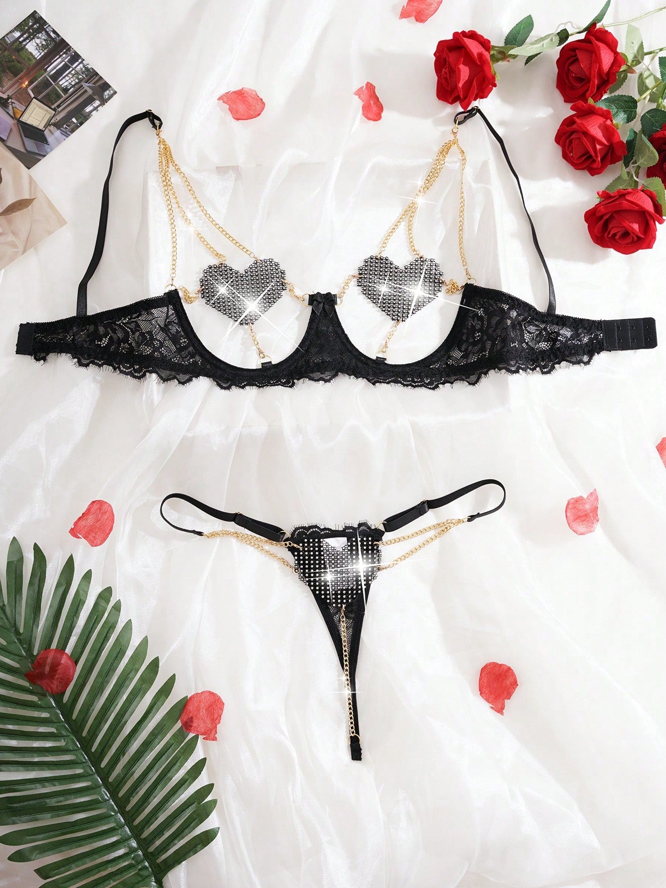 Women’s 2-piece sexy lingerie set featuring rhinestone and chain details, mesh and lace splice design, spaghetti straps, and a low-rise thong bottom; shown in black and red options.